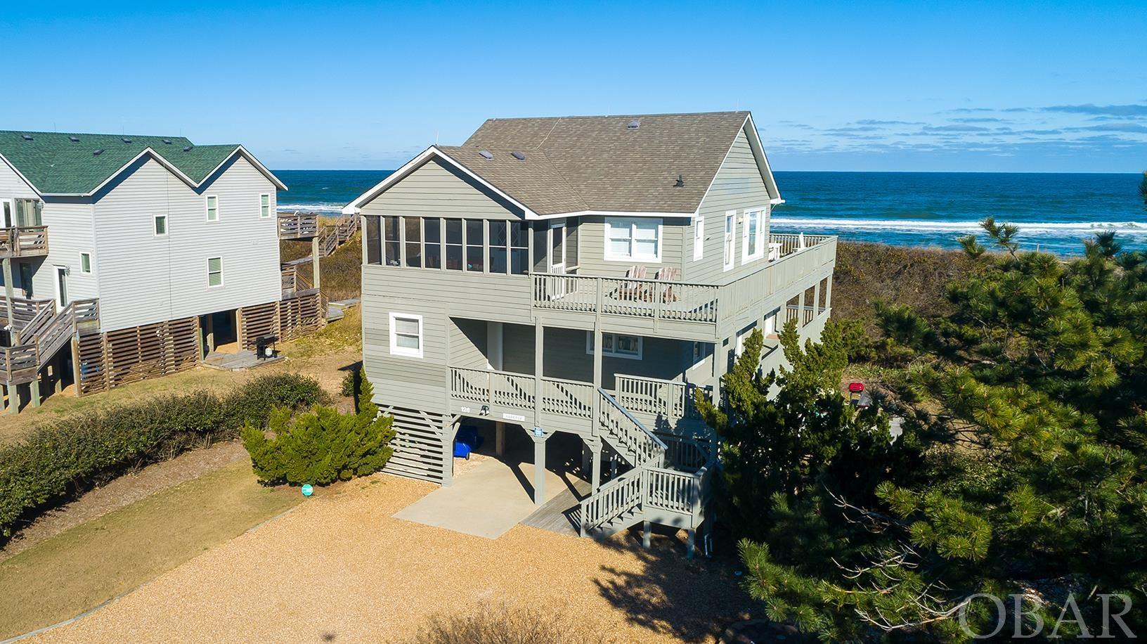 Stunning sunrise views over the Atlantic from this beautiful Sanderling oceanfront home! Beautifully decorated with bright, coastal décor and theme, this home is sure to please. Updated kitchen with tile floor, bar top seating, and newer appliances. Nice screened in porch off the kitchen area for when you want to enjoy your morning coffee, dine outdoors, or just read or relax and see and smell the ocean. Very spacious, open and bright top floor with fantastic views, complete with a sun room/siting area. Powder room located on top floor too. Mid level offers two en-suite bedrooms (one queen, one king), a bunk room and a twin room, each with their own bathroom. Great decks on mid level too! Great south side sun deck with surrounding landscaped area is perfect for afternoon cocktails and grilling. Relax in the hammocks under the house to enjoy those cool ocean breezes or soak up the sun in one of the rockers on the top floor sun decks. This property is well protected with a strong, vegetated dune. Enjoy all the joys of beachfront living with the beautiful Duck beach right in your backyard.  Enjoy the amenities the exclusive Sanderling has to offer, including community pool and tennis. Close to Duck Village for shopping and dining, and enjoy the nearby Sanderling restaurants, just minutes away. And don't forget the world famous Sanderling Spa! View the virtual tour of this home by clicking link or cut/paste into your browser: https://my.matterport.com/show/?m=WQY5dmU2Y1s&mls=1