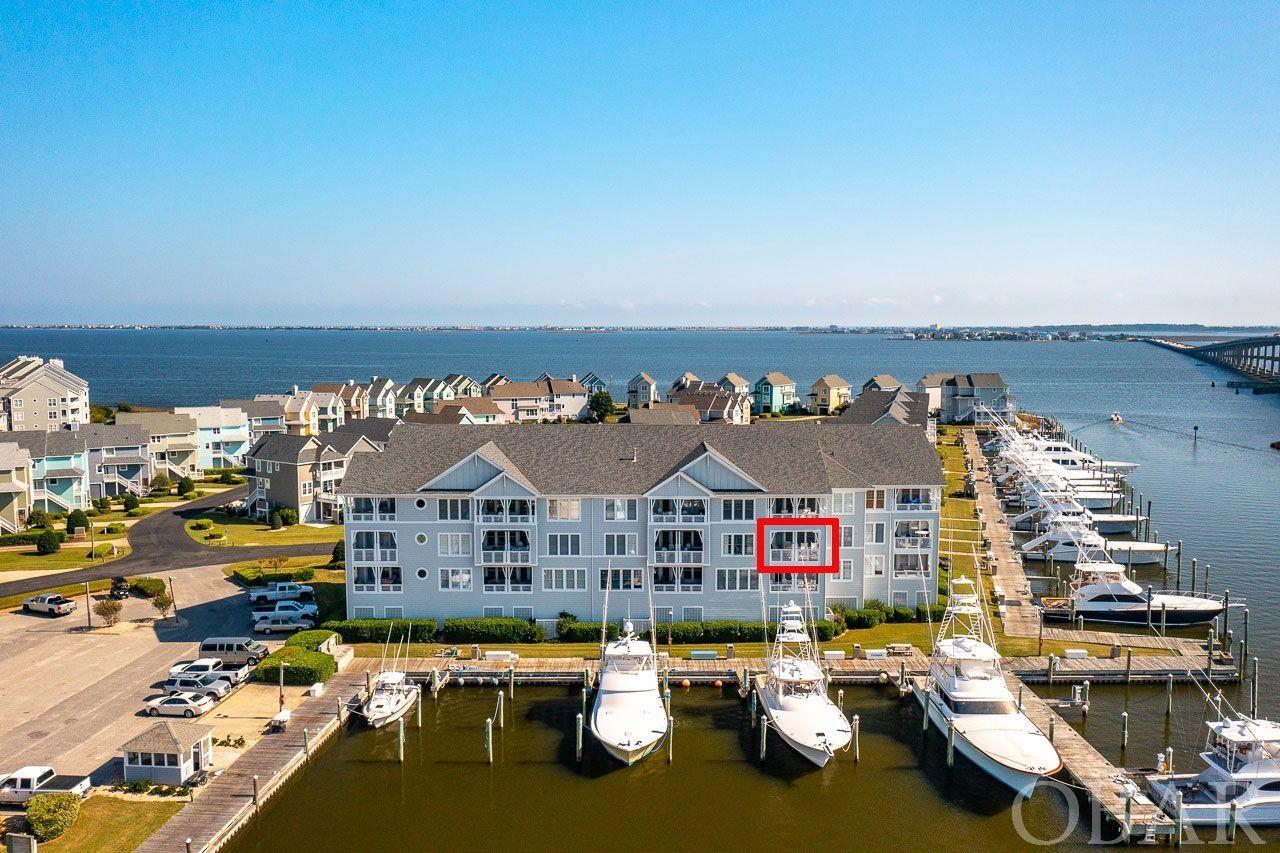 Once in a blue moon a unit in Gulfstream becomes available. If you've been waiting don't wait any longer! This unit has been lovingly cared for and gently used as a family second home. Mid level unit with incredible views of the infamous OBX Pirates Cove fishing fleet and harbor. Excellent floor plan. Large tiled entry foyer, custom built ins, 2 En suite bedrooms and 3rd bedroom with separate full guest bathroom. The waterfront En suite bedroom has double closet and access to the deck overlooking the marina. Large bathroom. Vanity has double sinks, stand up shower and jet tub. Open concept living, dining and kitchen area. Gas fireplace keeping you cozy by the fire on those chilly evenings. Stainless steel appliances in kitchen, pantry and eat in counter top for additional seating. Dining area can accommodate 6 comfortably. Large utility/laundry room AND the unit comes FULLY FURNISHED to include the polywood deck furniture! Turn key and ready for your enjoyment. Perks galore with the endless amenities in Pirates Cove. 2 community pools, clubhouse, fitness center, tennis courts, playground, miles of docks to explore, golf cart friendly, amazing sunsets, tiki bar, ship store, full service marina and outstanding restaurant. WOW! It has it all!  Would make a excellent primary, second or investment property. Come see this one today.