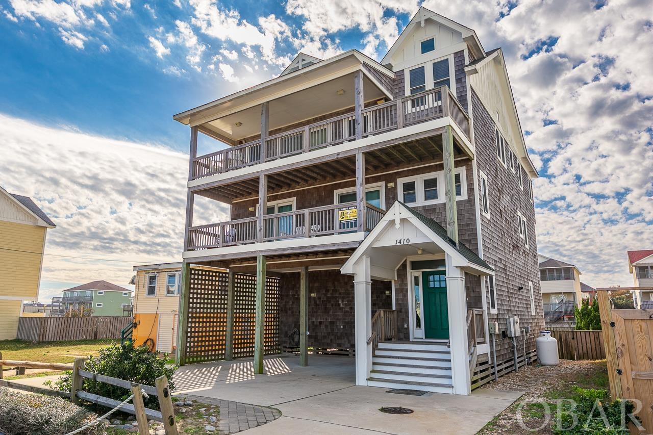 Custom Semi-Oceanfront with Private Pool & Elevator.  Built in 2014, this coastal retreat has all the features you need for your Outer Banks second home or investment property.  The Classic Outer Banks Style home boasts red label cedar shake siding with board and batten accents and spacious sun and covered porches on the second and third levels…all with SWEEPING views of the Ocean!  The top-level features an elegant kitchen with granite countertops, custom white beadboard cabinets, stainless steel appliances, and pendant lighting with a unique coastal feel.  The kitchen opens up to the tastefully decorated dining area and living room with wood vinyl plank and a gas fireplace - all with a stunning view!  The top-level also boasts a ships watch with a sitting area and a primary bedroom with an ensuite bath and walk-in closet. The mid-level features 3 additional primary bedrooms with ensuite baths and a second den.  The first level features a bunk room, full bathroom, fully equipped game room with a wet bar, pool table, and sitting area.  The backyard is ready to entertain with a fiberglass private pool, 6 person hot tub, gas grill, and outdoor speakers!  The property is handicap-friendly with an elevator that services all levels.  No detail was spared in this upscale, quality constructed home.  1410 S VA Dare Trl is an excellent investment property with potential for over 12% Gross Rental Return. It is centrally located near local favorite restaurants, shopping, and grocery stores, and is only about 230 yards to the closest beach access! Virtual Tour coming soon!  Check out what guests have to say: https://www.joelambjr.com/outer-banks-rentals/kill-devil-hills/087-pain-killer