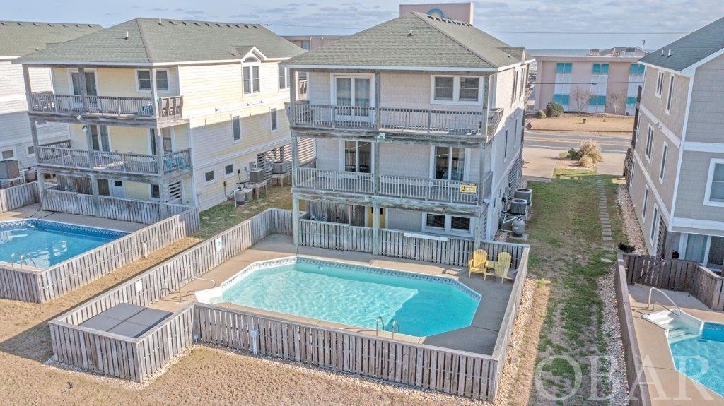 Fabulous Semi-Oceanfront Home in KDH ... Walk to beach access at 3rd street, walk to the KDH Movie 10 Theater, walk to the New (coming soon!) Target! *** Home Features 3 full living levels - Top Floor Level 3 Features Spacious Open Great Room w/ Volume Ceilings & Gas Fireplace (NOTE: No LP Tank onsite), Deep Front Covered Deck off the Great Room w/ some Ocean View through the Mariner Motel across the street * 1/2 bath Powder Room * Great Kitchen for Family's to enjoy. * Main Master Bedroom with Full bath *** Mid-Level 2 Features 3 Master/Main Ensuite Bedrooms, 1 Bunk Bedroom and 1 Hall Full Bath - you will love how the Hallway is Decorated *** Ground Level 1 Features Large Game Toom w/ Mini-Kitchen w/ Wet Bar, Fridge and Microwave, Foosball & plenty of Seating for when you want to get away for a break * 1/2 Bath Powder Room off Game Room * Main Master Ensuite Bedroom w/ Full Bath - altogether 6 Bedrooms, 6 Full Baths, 2 Half Baths! *** Exterior Features Double width concrete Driveway to handle the extra parking for larger families, plus Deep Carport * Great storage room at end of the Carport * Vinyl siding for lower maintenance exterior * Enclosed Outside Shower * Large Vinyl Liner Pool & Poolside Hot Tub ... all you need to do is to add a Tiki Bar & you'll be set! *** Joe Lamb Realty Rental Ad: This Splendid vacation home is Loaded w/Amenities that are Sure to Please your Entire Family. It Offers areas for Everyone to Relax & Enjoy, a Spacious Living/Dining Area, Cozy Den, & a Rec. Room w/Foosball Table & Wet Bar. Take a Dip your own Private Swimming Pool (16 x 30), or Ease into the Hot Tub; All You Need for a Great Vacation is here at Pirates Retreat! Access to the Beach is Only 50 Ft. Away (Just Across Beach Road) at the Pedestrian Crosswalk. You'll love the central location in Kill Devil Hills. * Ground Level: Parking for 4 Cars, Covered Entry, Rec. Room w/Foosball Table, TV, Wet Bar, Half Bath, Laundry Area, Master Suite w/King, Full Bath & Smart TV, Private Swimming Pool, Hot Tub, Enclosed Outside Shower, & Charcoal Grill. * Mid-Level: 4 Bedrooms (2 Master Suites w/Queens, Full Baths, & Smart TV, 1 w/2 Doubles, Full Bath, & Smart TV, 1 w/2 Duo Bunks, Full Bath & Smart TV), Front Covered Deck w/Deck Furniture, & Back Covered Deck w/Deck Furniture Overlooking Pool Area. * Top Level: Spacious Living/Dining/Kitchen Area, TV, DVD, Half Bath, Partial Ocean Views, Master Suite w/King, Full Bath & Smart TV, Front Covered Deck w/Deck Furniture & Ocean Views, & Back Covered Deck Overlooking Pool Area. * Features include C/AC & Heat, Washer/Dryer, Dishwasher, Microwave, 2 Full Size Refrigerators, Phone, Wireless Internet, 8 TVs, DVD, Baby Equipment (Highchair), & Deck & Pool Furniture. Located Next to #363. No Pets. This is a Non-Smoking Unit. End rental ad *** Home is sold completely furnished and ready for you to enjoy! Purchase now (January) and have maybe only 9-10 months ownership expense for 2022 ... but you will capture most all of the rental income for 2022 - which is right now as of Jan 10 at $68,000 owner rental income *** Note that 2021 Owner Income for the year was $69,969 - so already in January 2022 the 2022 rental season booking a but equal all of the rents that we obtained in 2021 ... room to go higher this year *** Home is a weekly vacation rental with a Saturday Turnover Day in season ... as of Jan 10 the first booked week starts 5/21/22 *** This home is centrally Located X Flood zone so NO Flood Insurance required ***Central location close to Publix and Lowe's, restaurants, Miniature Golf, Wright Memorial, Jockeys Ridge and ... of course the Beach! *** Come See!
