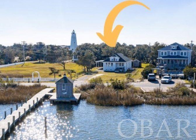 A RARE OPPORTUNITY to own the MOST PHOTOGRAPHED PROPERTY on Silver Lake with 'net house' and boat dock/pier! Most often the majestic Ocracoke Lighthouse is photographed in the background, making for a stunning shot!! Formerly owned by the Burrus family, this charming historic home was built in 1934 by Charlie Scarborough and his brother, Thad, for Lonnie Burrus, Sr. The current sellers saw that it was for sale while vacationing on the island many years ago (in the 1980's) and just fell in love with it; the rest is history! Speaking of history, this home is on the US Dept. of the Interior/National Park Service/National Register of Historic Places/Ocracoke Historic District, Hyde County. You may know it as "Chadwick South," as it was in a vacation rental program for the prime summer weeks for many years. Ocracoke Island is only accessible by ferry from Hatteras Island to the north, from Swan Quarter or Cedar Island to the south and west, by private boat or yacht, or by private plane. While the home has a NEW ROOF (July 2020) and NEW SIDING REPAIRS (Completed December 2020), it is being sold "as is" in its post-Dorian 'ready-for-new-owners-to-put-their-mark-on-it' condition. Perhaps new owners will prefer to have the house lifted, preserving the historic island cottage charm while maximizing the spectacular expansive views of Silver Lake Harbor! The interior offers a blank canvas, allowing the new owners to remodel to their sense of style and creativity in selections of cabinetry, plumbing fixtures, flooring and lighting...an opportunity to personalize to one's tastes and budget. LOCATION, LOCATION, LOCATION!