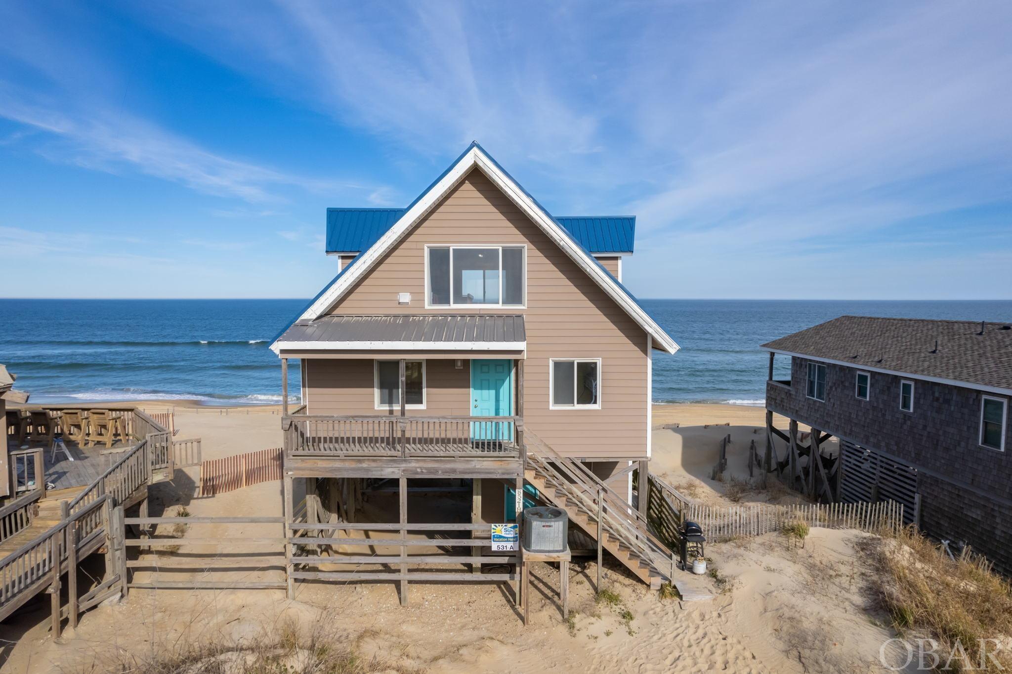 Classic Nags Head oceanfront vacation property with growing 2024 rental income available!  Enjoy gorgeous ocean views at this 3 bedroom/ 2 bath cottage located on a cul-de-sac street close to Jennette’s Pier and the Outer Banks Fishing Pier.   The main floor features an open kitchen/dining/family room area- all with those captivating ocean views- and an expansive oceanfront deck which provides an unobstructed view up and down the beach making this property a favorite with vacation guests.  The spacious open floor plan boasts easy care flooring, warm wood tones, oversized windows, and plenty of space for the whole family.  Two guest bedrooms, a full bath, and the pantry/laundry area are also conveniently located on this level.   The upper level primary en Suite is a private oasis unto itself.  The large windows, private full bath, spacious sitting area, balcony, and spectacular ocean views set the stage for relaxation and tranquility. Well maintained, this home has Everlast Siding with a wind rating of 160 mph, a metal roof and LVP Lifeproof flooring (mid-level 2022), new family room furniture (2022) and a new (2020) HVAC.  There is nothing that a buyer would need to do to jump into the rental season.  This vacation rental has wide appeal due to its oceanfront location and proximity to local shopping, restaurants, and attractions.