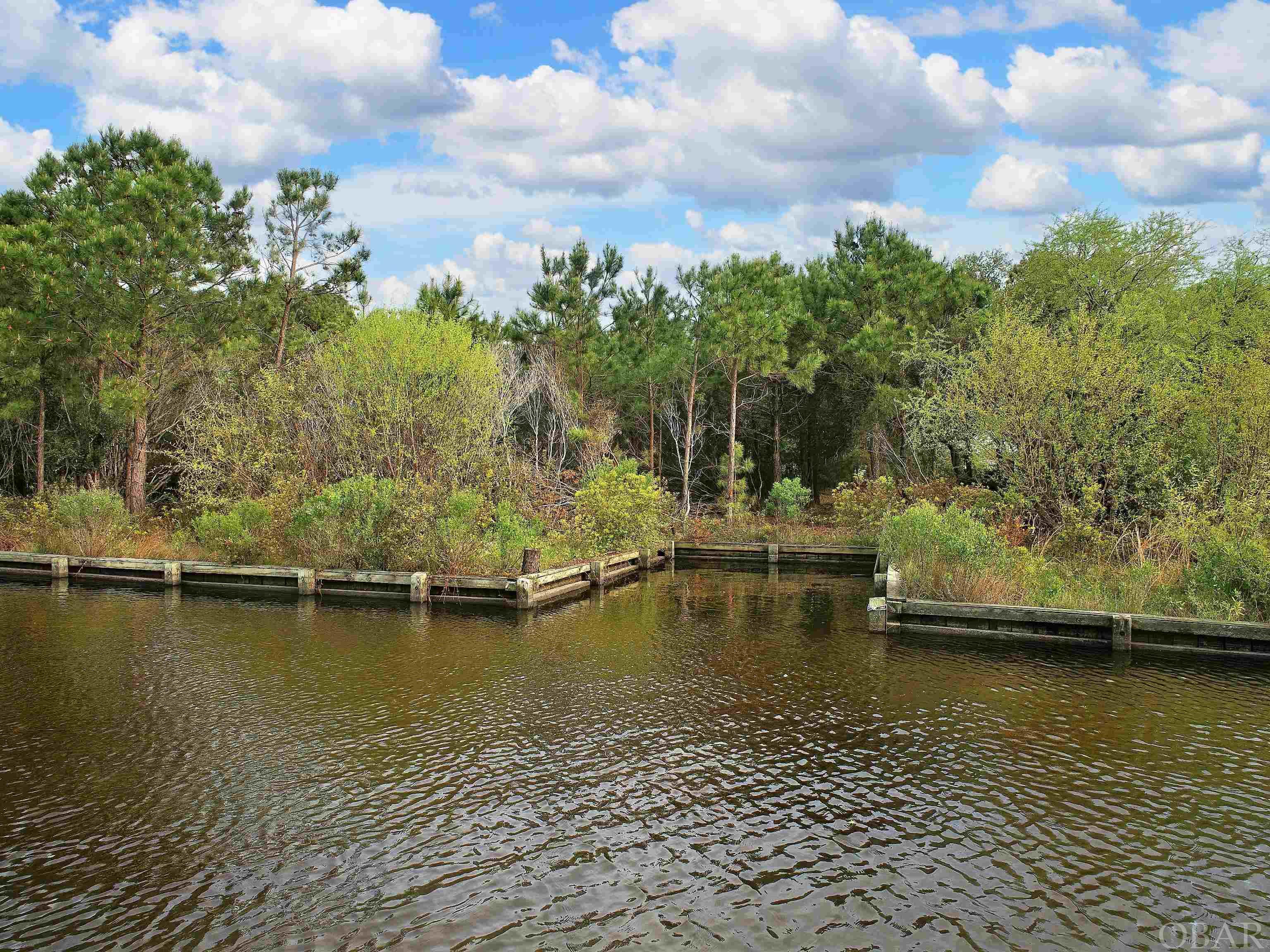 Ready to trade in the pavement for a life on the water? Look no further! This breathtaking canalfront lot in Carova Beach is the perfect spot to build your dream home. Partially cleared and already equipped with a bulkhead and boat slip, this lot offers endless possibilities for waterfront living. Plus, with its close proximity to the entrance to the sound, you'll have easy access to all the boating and water activities you could imagine. Imagine waking up to the peaceful setting of this lot, which is perfect for your private sanctuary. Choose your dream home plan and builder, and start living the life you've always wanted. Don't miss this amazing deal - act now!