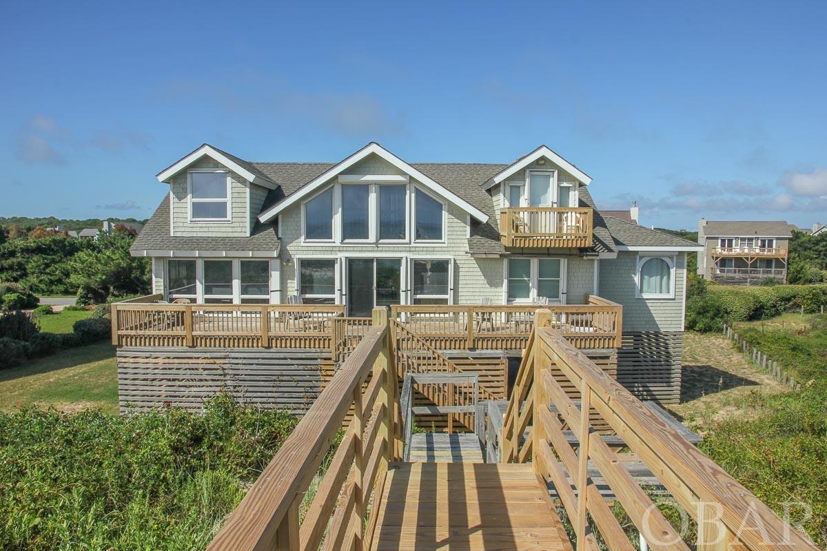 NO SHOWINGS UNTIL FRIDAY MORNING 2-25-22. OCEANFRONT in Sanderling! 5 master bedrooms! 5 1/2 baths. Well cared for and maintained oceanfront beauty. Nice open living area with a two story high cathedral ceiling with a two story high wall of windows making you feel like you are outside. Bright, open kitchen with granite counter tops and stainless appliances. Newly installed hardwood floors in the kitchen and great room. A spacious dining room is just off the kitchen and has a wet-bar and mini fridge with access to a large south west corner deck. The main master bedroom boasts a beautiful new master bathroom with a whirlpool tub and a large, artfully tiled shower. This bathroom has its own dedicated hot water heater and there is another hot water heater for the rest of the home. In addition, a large ocean side deck extends the entire width of the house. Upstairs are two more master bedrooms, one with its own small oceanfront deck. Connecting the two bedrooms is a two-way lookout loft serving as an additional social center with magnificent ocean views. Just off of the loft is a huge westside sun deck. Convenient dry entry with plenty of storage on the ground floor, a one car garage and a second full size refrigerator in the owners lockup that conveys. Sold fully funished except for contents of ground floor locked storage units. There is even a convenient ground floor ocean access half bath. Plenty of under house parking. Very privately located off the road with a long driveway. Anderson windows and sliders. Storm shutters. Tucked behind a firm, substantial dune. This home is a rental machine taking in $78,739 in Advertised rental income in 2021. Join the Sanderling Racquet and Swim Club for $1,950 per year. Look in Associated Docs for Rental Print outs, Aerial Photo, County Survey and Permits, RPD/MOG etc. County shows this as a FOUR bedroom FIVE bath with a sleeping capacity of 12.  See permits in Associated Docs. EZ to show. Coded entry.