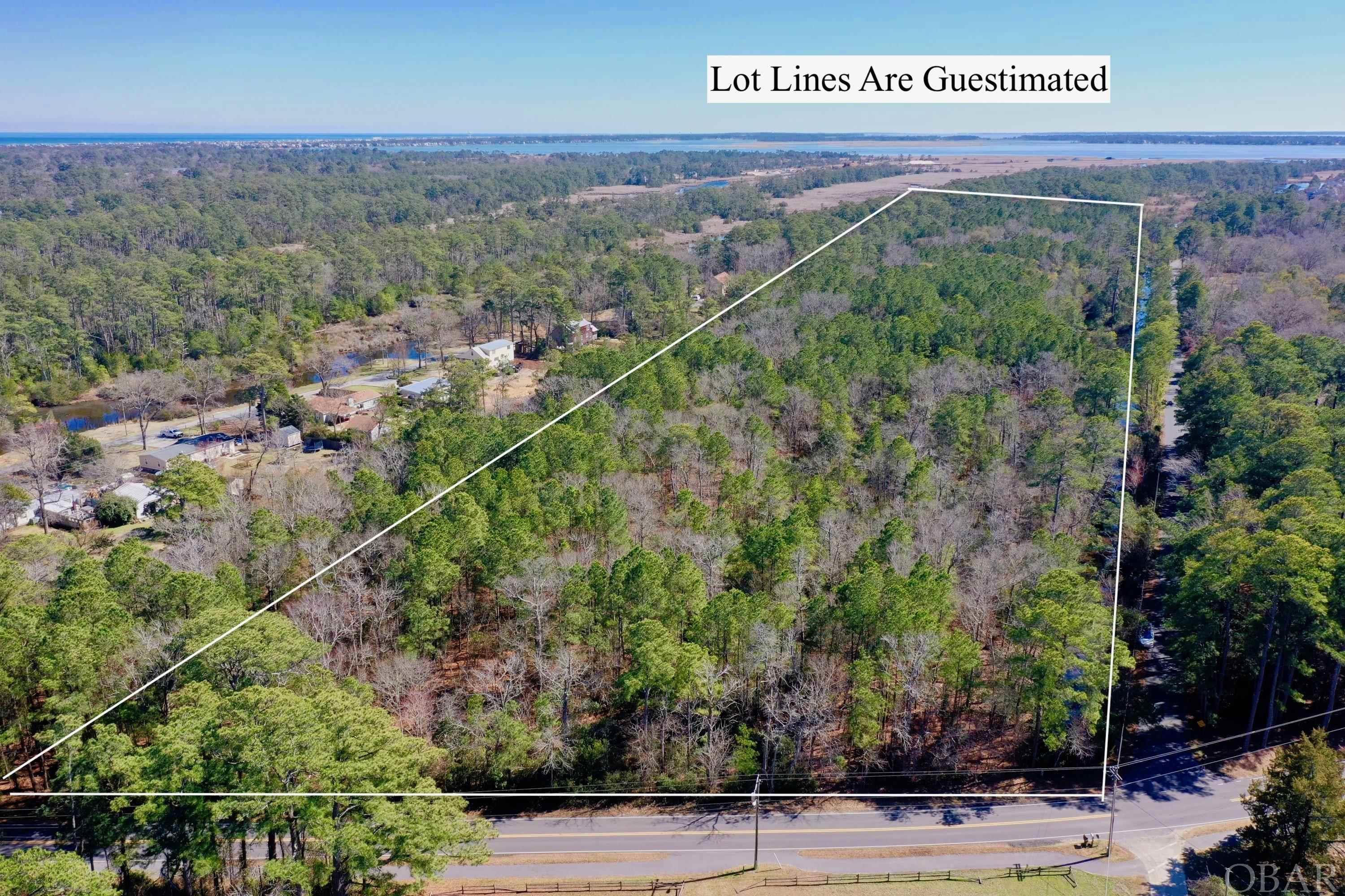 Imagine the possibilities with this beautiful 26+ acre parcel located in the heart of Kitty Hawk Village. Enjoy consistent elevations of 10 ft to 18 ft along the natural ridge running through the property and creating some of the highest and most beautiful land in Kitty Hawk. Savor this extraordinary location adjoining the Kitty Hawk Woods Preserve which includes 1,890 acres of maritime forest, sand dunes, hiking trails, and canals. All this right outside your door with the ultimate backdrop of serenity in the woods. When walking the property it feels like you're being hugged by nature; so beautifully relaxing and surrounded by the purity of wildlife, trees, birds, and more! The natural vegetation, high ridges, and tranquil setting create a ONE OF A KIND location and opportunity. You truly have your very own nature sanctuary while being minutes from beach or sound! Here's your chance to have a little bit of country, privacy and seclusion, in the middle of the hustle and bustle of beach life! The possibilities are endless; Zoned VR-1 Low density Village Residential District: Bed and Breakfast, small subdivision, horse farm, or homestead. Some preliminary work for a subdivision has been completed and in associated docs, but please note that was only for 22 acres. This parcel includes Lots # 4, 5, 6, 7, 8 and 9. Please call listing agent to assist in walking the property.