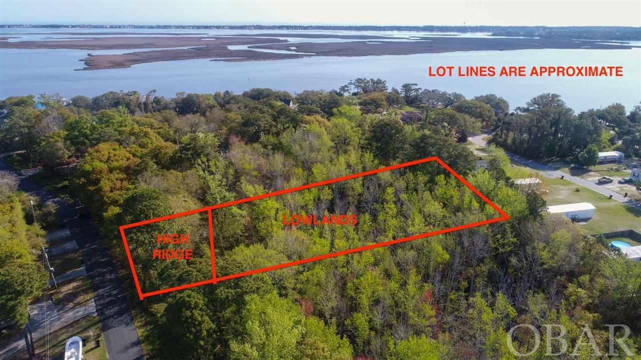 A great opportunity in Colington Harbour.  2 lots for the price of 1!  There is a VERY high ridge on both lots that is near the road that would make a great building site for your new home.  From that high elevation there should be beautiful and tranquil views overlooking the property below.  From the ridge at the road, the grade drops off severely into lowlands.  Some preliminary study showed the two lots both being buildable.  The seller believes this may be possible with significant site work.  In order to avoid costly site work, the seller has made these 2 lots available together so a home could be built on both lots together utilizing the space on the high ridge for development.  A great opportunity!  Go take a look!  ***In one of the pictures there is a white stake.  This stake marks the northern most part of these 2 lots.  The property for sale starts on the right side of the post as seen from the road. Do not trespass on the property to the north.***