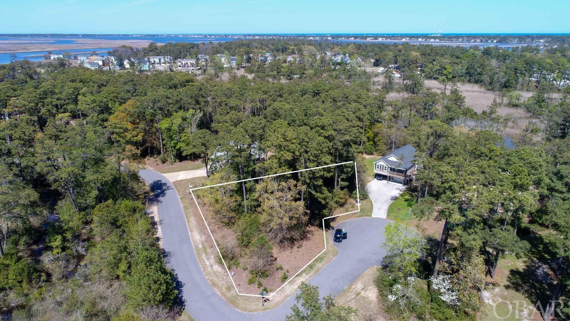 Sunrise Crossing, one of the last buildable lots in the community. Sought after area with privacy and convenience to all the Outer Banks has to offer. Sellers have had a custom 4BR, 3BA home drawn for the lot by Florez & Florez, which will convey to new buyers. The community offers newer homes and a community dock/pier. Near Shopping, restaurants, schools, Wright Memorial, bike/walking paths and parks.  Public beach access just minutes away.