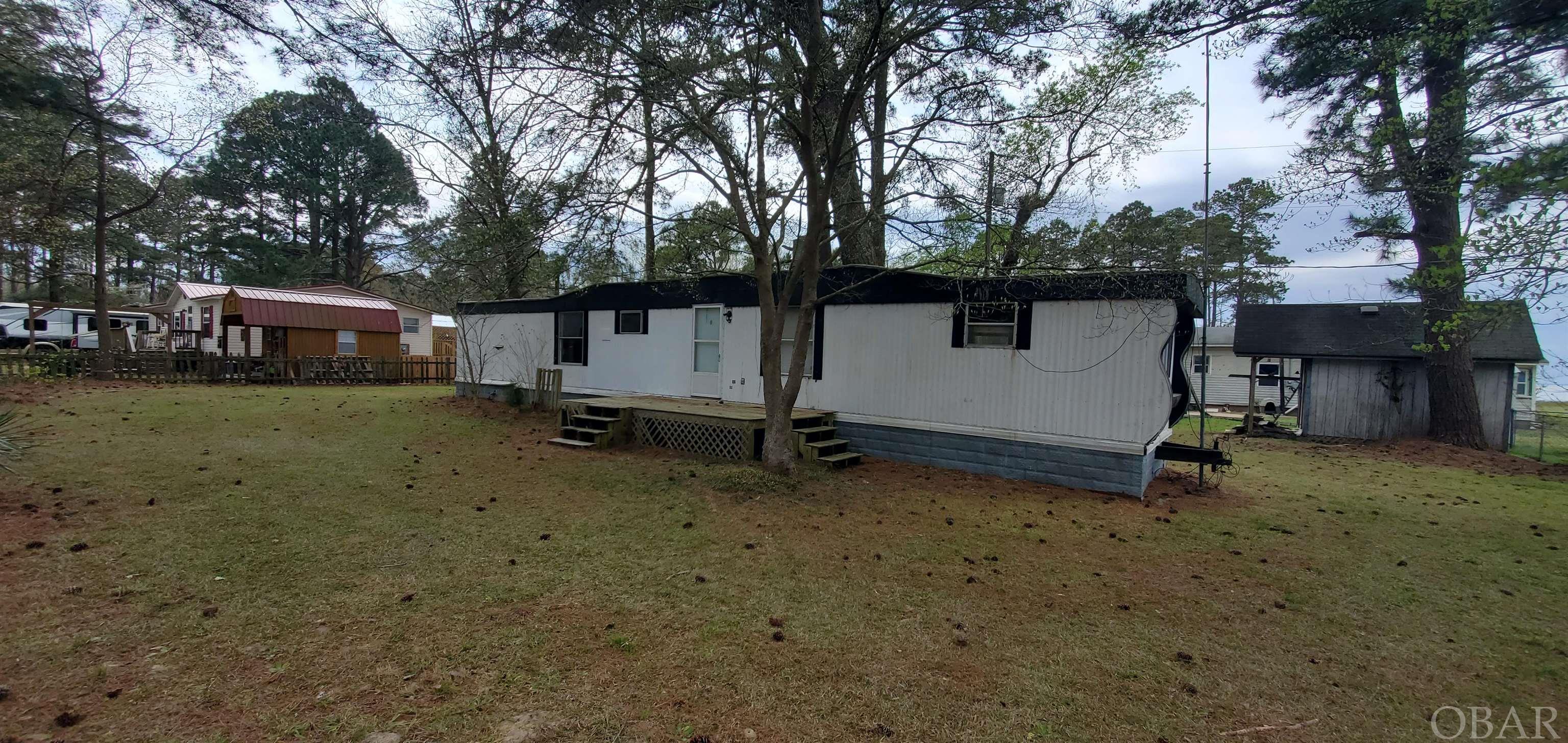 Imagine being surrounded by tall Pines and seeing amazing water views of the Albemarle Sound right from your back porch! This older single wide mobile home holds a lot of memories but needs TLC to be livable again. The property's location in the Va-Lee Beach community is close to the sound yet on high ground. Store all those fun water toys in the small shed and be ready for summer. This private, peaceful community provides you with direct access to the Albemarle Sound from the community boat launch with no HOA and no Fees! Va-Lee Beach is on a paved, Dead End road. Pets are welcome in this family friendly waterfront community. Being offered at Land Value only price.