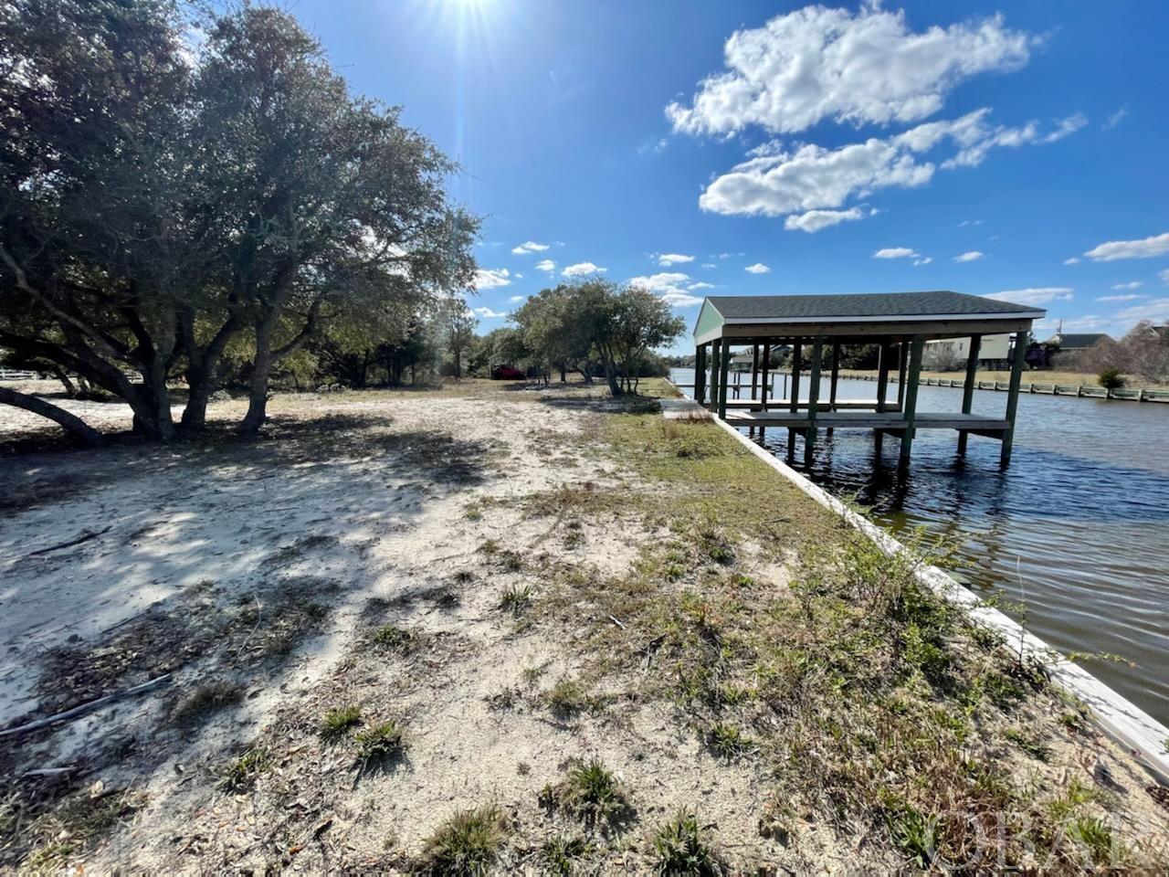 Beautiful ready-to-build canal front lot is located on Carova Beach. Ideal Location across the street from Carova Boat Ramp and Beach Park. This is a perfect location for your newly- constructed permanent, investment or vacation home! Watch the wild horses along this quiet beach, relax and enjoy the OBX.  Newly bulk headed with a boat house that encompasses 3 boat parking and two 6' x 24' piers on a recently dredged canal. Brand new septic and well installed. House pad is ready. 100 amp electric pole installed. Stick-built shed.