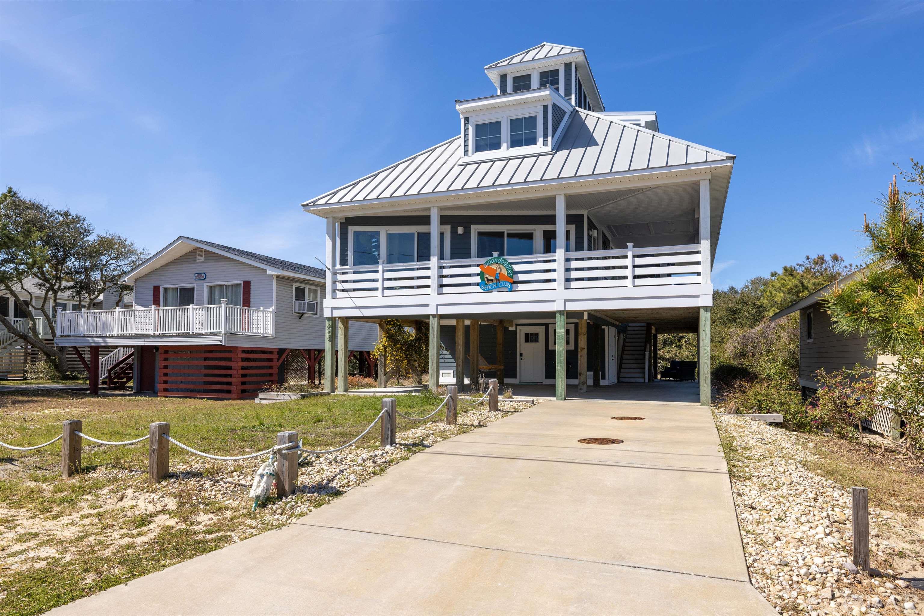 SELLERS CALLING FOR HIGHEST & BEST BY 5PM 4/2. With around 56K gross rental income for 2021, visitors and buyers alike can agree that Moondoggies Beach Club is the perfect beach retreat!   Moondoggies was built in 2016 and is like-new!  The interior and exterior were thoughtfully designed and decorated and include plenty of upgrades such as the metal roof, indoor/outdoor gas fireplace, and shiplap. Walk in from the ground level to be greeted with fun, coastal tile and bright wooden stairs.  The second level has an open floor plan with a beautiful well-equipped kitchen featuring quartz countertops, open shelving with a tiled backsplash to the ceiling, free standing range hood, built-in microwave, and a custom wooden surfboard bar.  The living room is cozy and inviting with the indoor/outdoor gas fireplace. The second level also features a full bathroom with a double sink vanity and tiled shower, and two bedrooms, both tastefully decorated.  The third level has a master bedroom with a king bed and a single day bed and an ensuite bathroom with a double sink vanity and white subway tile shower.  The additional room is used as the 4th bedroom and includes two twin beds and a small sitting area.  Last but not least, the 4th level features a crows nest inspired area with comfortable cushioned bench seating and ocean views!  In addition to the exquisite interior, the outdoor space is just as inviting!  The wrap around covered porch includes low maintenance vinyl railings and cozy seating to enjoy the fresh salt air.  The ground level has an additional seating area, hammock, and outdoor shower.  The property is centrally located in Kill Devil Hills and is close to the beach (0.3mi), sound, Bay Dr multiple-use path, local restaurants, and entertainment.  The Avalon Association includes a beach parking pass by the Avalon pier for only $30/yr. This property is bursting with character and could be used as a primary, secondary, or investment property.  Check out what the guests have to say about this coastal retreat! https://www.airbnb.com/rooms/20064032?source_impression_id=p3_1564494225_c8V5%2BEzi1zPL69FF&fbclid=IwAR2AnJeumChRijR046xFSgCs6T1sHUuvreM7pj10V7arEOSxh99Cy2Bxz9o