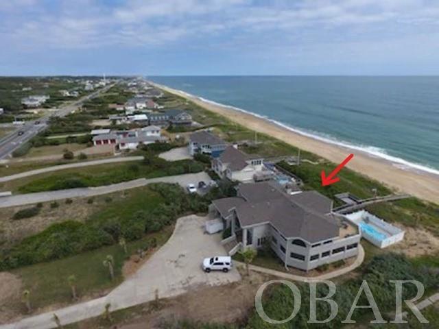 HUGE PRICE DECREASE! Oceanfront in Southern Shores. Huge, high elevation oceanfront lot. Six Bedroom, four and a half baths. Enormous and impressive living area!!! Heated POOL, hot tub, and ELEVATOR. Huge open living area with views of the surf. Beautiful hardwood floors. Features a magnificent stone fireplace, wood burning, with built-in entertainment center. Gorgeous juniper cathedral ceiling. Large gourmet kitchen w/sub-zero refrigerator, and two ovens. Corian countertops. Impressive, curved breakfast bar and huge dining area with new 10-person dining room table. Accent lighting surrounds the dining room that looks out to the huge screen porch. The floorplan is not your usual rental layout. This was originally built as a year-round home, but it is a VRBO RENTAL MACHINE!!!  $210K booked already for 2022. $197,954 Gross rent for last year. Look up Carrocce Sea Ranch on VRBO or Google it for more information.   Sprinkler system inside for fire security. Every bedroom has access to decks leading to the private beach walkway with dune top deck. Top floor master bedroom suite has an impressive master bath with jacuzzi and separate dressing room and sitting area. First floor has five bedrooms, two being master bedrooms, one featuring a jacuzzi. Spacious laundry room. Plantation shutters, heavy duty screens on many sliders. Some have very substantial high-end curtains. New pool 2015, new hot tub 2019, roof just replaced in 2015, brand new pool heater heat pump. Heavy-duty high-end Andersen sliders. Huge 2 car garage finished into game room with TV and extra refrigerator. This room is not air conditioned but has fans to keep you cool. You can open the garage doors and it’s like you are outside. New pool table, shuffle board and arcade machine with 130 classic games. 2 enclosed outdoor showers. Immaculate inside. Needs a few shakes replaced, full paint job outside and some screens replaced. Sold FULLY FURNISHED except items in locked owner’s storage. There is a huge amount of parking! Life guard stand just 400 feet to the north. This is a very desirable oceanfront lot! Look in Associated Docs for RPD/MOG, VRA, Bill of Sale, Plats, Survey and Permits. For a low $95 per year the Southern Shores Civic Association lets you take advantage of three sound side marinas with picnic and crabbing areas, Private Sound Beach, thirty-four Private Ocean Beach accesses, parks, basketball and soccer fields. For an additional fee you can join the SSCA tennis courts. Combo lockbox.  Key is hard to work, but it works.  EZ to Show!