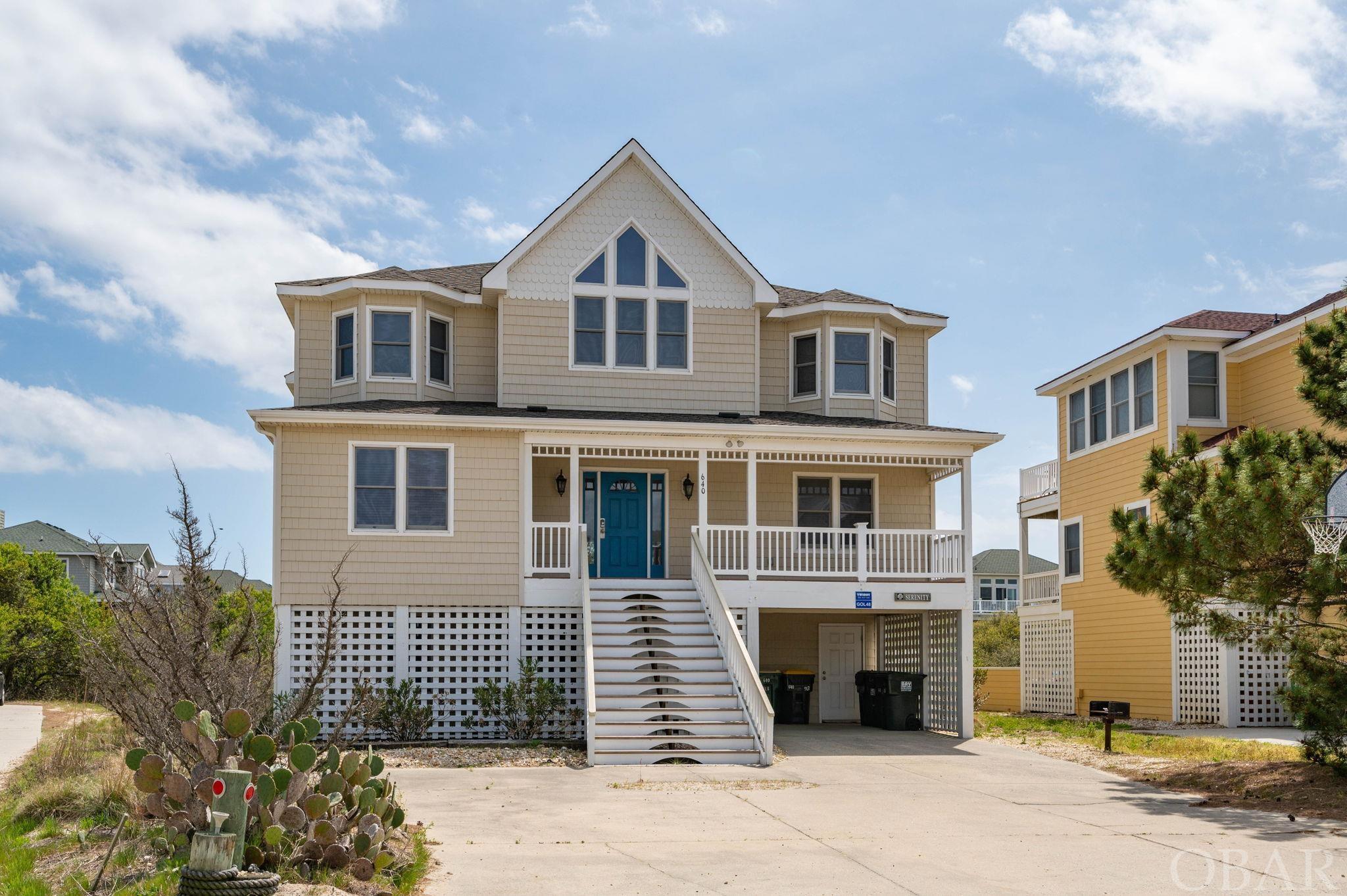 Lowest price per Square Foot of any Corolla semi-oceanfront!  Located in the desirable Ocean Lakes section of Ocean Sands, this 7-bedroom turnkey home features ocean views and is just steps to the beach. Enjoy the privacy of the Ocean Sands green space behind the home and the convenient location of the beach boardwalk at the end of the driveway.  The upper level of the home is comprised of a spacious open flow floor plan- family room with cathedral ceilings and fireplace; an oversized dining area; and the kitchen with breakfast bar seating and ample storage/counter space.  Enjoy ocean views from the Ships Watch or step outside onto the ample sundeck to enjoy the morning sun rising over the Atlantic.  There is also a half bath on this level as well as the Primary en Suite.  This top-level bedroom boasts privacy, space, ocean views, and a separate bathroom with an oversized walk-in glass shower and double vanity.   Take the elevator down to the mid-level where you will find four more en suite bedroom with private bathrooms, and another bonus room/office set up as sleeping space.  An ocean side covered deck runs along the southern elevation, providing convenient access to the new mid-level Jacuzzi Play hot tub.   The ground level features two more bedrooms that share a full hall bath, and a spacious rec room with wet bar and adjacent half bath.  The comfortable game room has plenty of room to play pool, stretch out and watch TV, or just relax and cool off after a day in the sun. “Serenity View” checks all the boxes for a vacation property- ocean views, open concept floor plan, large en suite bedrooms, elevator, and game room with wet bar.   Situated on an X flood zone lot and convenient to the attractions, shopping, and dining of the northern beaches, this vacation property offers the proximity, updates, and space the discerning buyer is looking for.