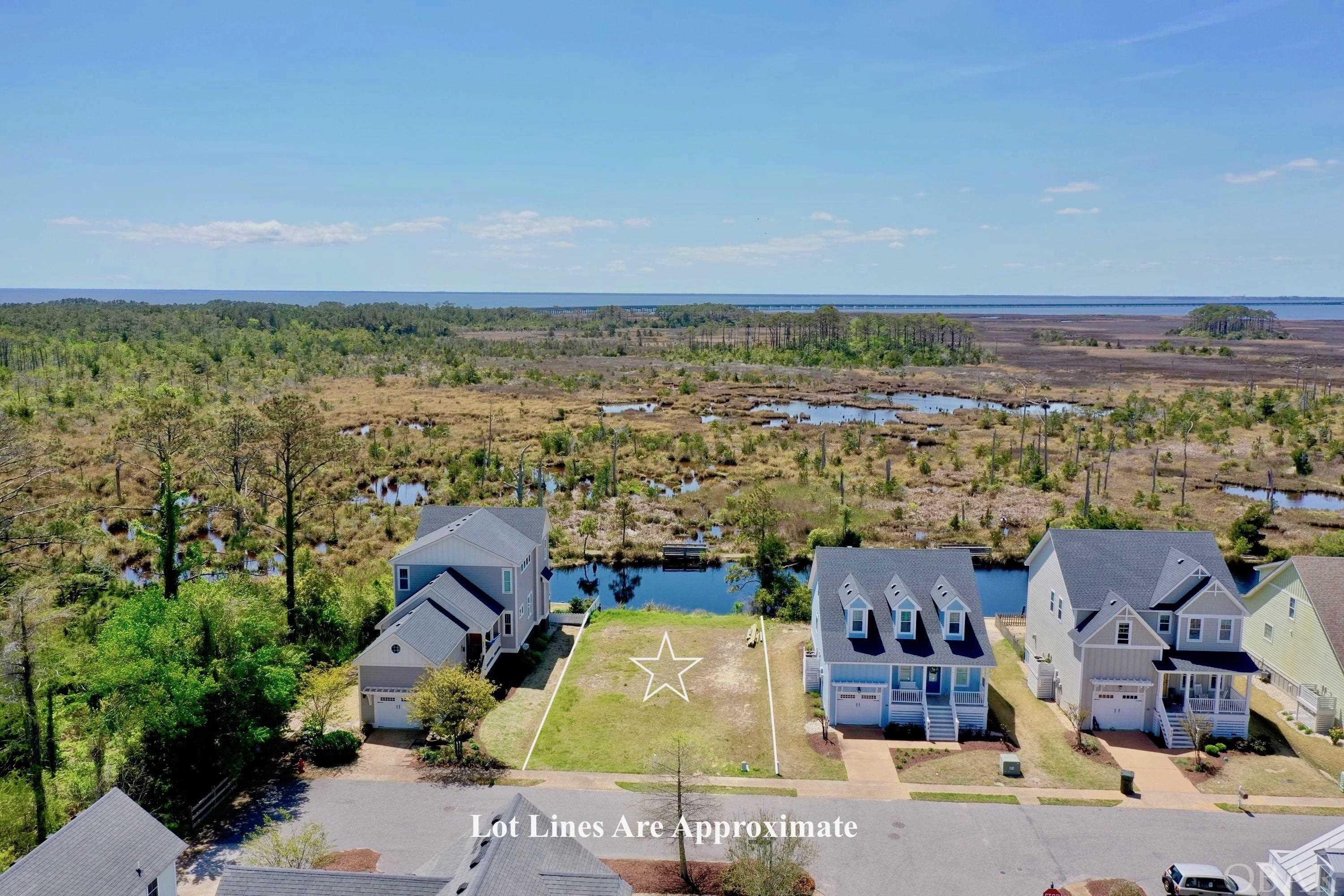 One of the few homesites remaining in "Cypress Cove" located in the charming Town of Manteo. Cypress Cove has 32 sites and is an established neighborhood with landscaped properties, homes built in the beloved Manteo Architecture, nature trail, and common areas with views of the salt marsh and Croatan Sound. Manteo is one of the oldest towns in North Carolina, full of history, and rich in culture. Walk or bike to concerts, restaurants, enjoy the Saturday morning Farmers Market, or the Downtown First Friday Celebrations, walk one of the longest contiguous boardwalk in coastal North Carolina, and shop at locally owned boutiques. This level and cleared lot is ready to build on showcasing incredible sunset views and is ideally located on the quiet back side of the community. Enjoy watching the serenity of the pond from your back deck or gazing at all the wildlife playing over the marsh. Only minutes from the beach, downtown Manteo, and the Roanoke Island Festival Park. Municipal Water and Sewer is available. The HOA fee is $520 for vacant properties and includes landscape maintenance, for improved properties the fee is $1,750 and again, includes landscape maintenance and common areas. Please note the sewer impact fee for the first two bedrooms has been paid totaling $1,920. Don't forget to check out the virtual tour link for aerial video.