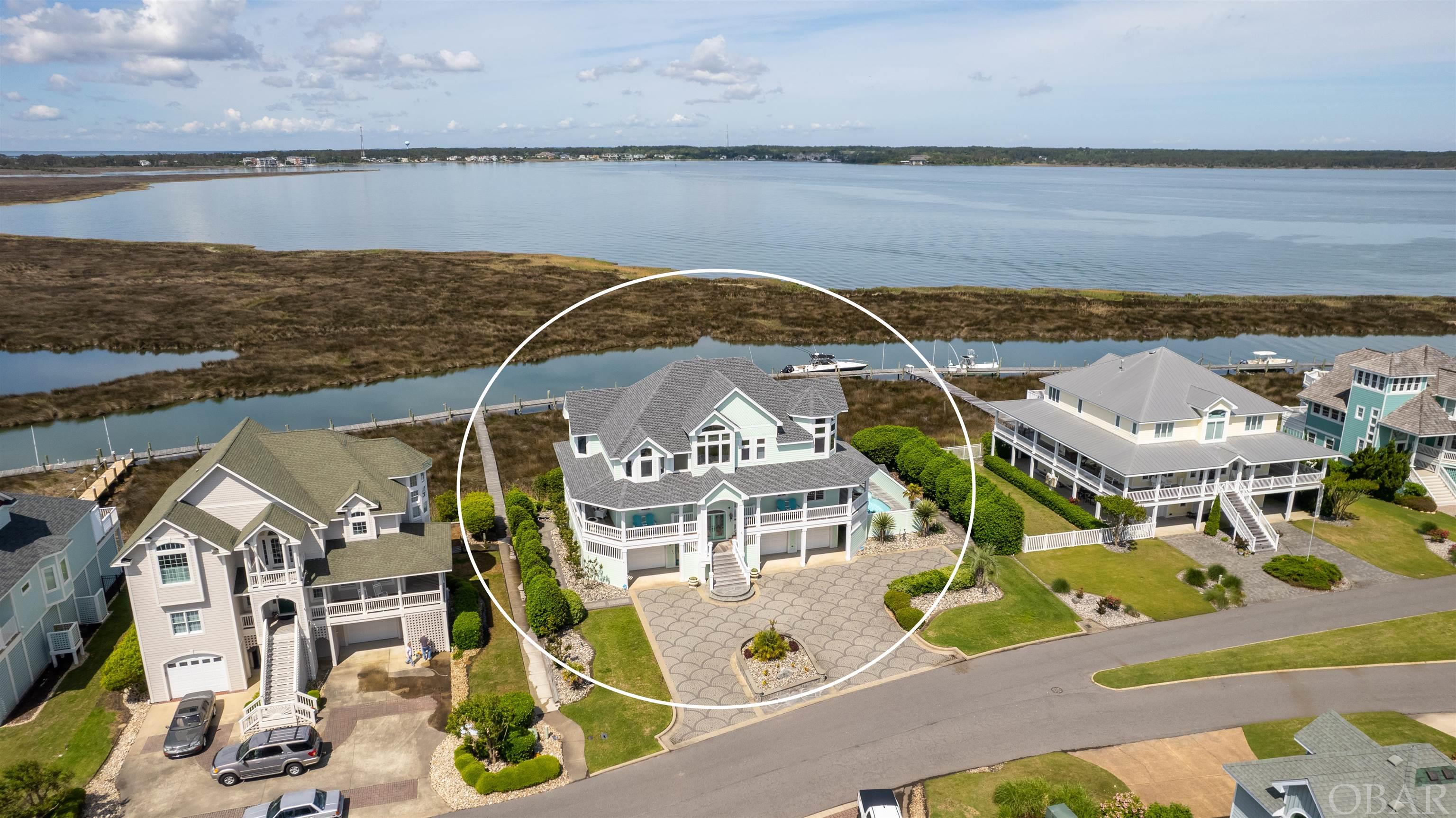 STUNNING WATERFRONT HOME!  BREATHTAKING VIEWS FROM EVERY ANGLE!  Located in the premier waterfront community of Pirates Cove, in the highly coveted/upscale Ballast Point, this is a dream home boasting unobstructed views of Shallowbag Bay and the Roanoke Sound!  Beautifully designed and tastefully appointed!  5 bedrooms (all king beds) and 5.5 baths!  Well executed floor plan featuring one level living on the top floor which is accessible by elevator!  Open and spacious great room featuring a wet bar and ice maker.  Gorgeous kitchen with butler pantry...perfect for entertaining and family gatherings!  Beautiful master suite featuring 2 walk-in closets, custom tile shower, and private access to top floor deck!  Mid level has four spacious bedrooms (2 en-suite) that surround a common recreation area. The ground level features a spacious and fun recreation room with kitchenette!  Awesome multi-level outdoor living spaces including Ipe wrap around decking, covered porches, in-ground waterfront pool, hot tub...all with incredible views of the Roanoke Sound!!  Gorgeous cobblestone driveway! Tiled and climate controlled 3 bay garage with commercial ice maker!  House is also wired for a generator!  Featured Updates include: New fortified roof, new on demand gas water heater with pump, 8 brand new smart TVs, all Anderson windows & all faucets have been serviced, reinforced bulkhead, brand new outside shower and hot tub, and so much more!  Enjoy the Pirates Cove lifestyle and take in all of the amenities that this premier, gated community has to offer including clubhouse, swimming pools, tennis courts, fitness center, playground, on-site waterfront restaurant, and boating/world-class fishing marina! There is a 35' slip reserved for your boat w power & water at the dock!  A MUST SEE!!