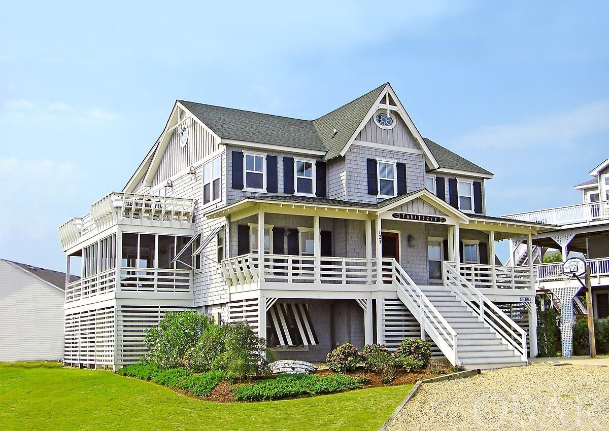 A classic Old Nags Head style cottage complete with cedar shakes and wrap-around decks that sits high on a hill in the private Four Seasons community of Duck boasts panoramic ocean views!  With 7 bedrooms total, 6 of them having their own en suite bathroom, there is plenty of room for the whole family. This idyllic coastal retreat has a gameroom with kitchenette on the ground level that leads out to the private pool area with NEW hot tub, where you'll find a shaded tiki bar, great for enjoying an afternoon cocktail after a long day at the beach. The mid-level hosts 4 bedrooms and large screened in porch, and on the top level you'll find a comfortable living room with gas fireplace, kitchen and large dining area that leads to another large deck and screened porch to take in the views of the Atlantic.  Easy walking distance to the boardwalk in Duck where you can enjoy fabulous restaurants and shops, and just an easy stroll to the beach. Hop on the neighborhood shuttle to get directly to the beach or oceanside pool, the clubhouse, tennis courts, indoor pool, or fitness center.