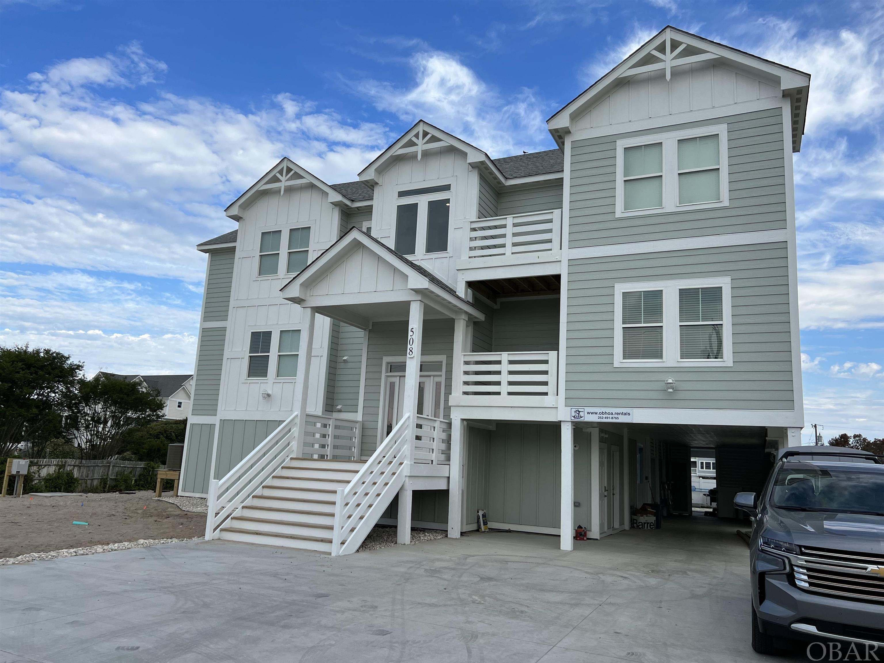 Spectacular brand new nine bedroom home in Ocean Sands Section B; brand new for 2022 season, ready end of May.  Estate size lot just steps to the beach access.  Elevator access to all levels. All of the nine bedrooms have private ensuite baths. Check the surf from the ocean views on the top floor.  Beach access is less than thirty second walk. This house will be a top producing rental with all of the amenities for discerning guests. High quality composite smart board exterior siding with custom trim. Interior is custom trim with high end furnishings. Loaded with extras. Smart home wired throughout; locks, thermostats, Sonos sound system with speakers inside and out, all Samsung Smart televisions. Two tankless gas hot water heaters.  Three level home, the ground floor has elevator access, full bath, large rec room with wet bar and full size counter depth refrigerator, plus theatre room. Second level has six total bedrooms three kings, one queen and two custom built in bunks rooms, each with two twins over two fulls for a total of eight beds between the two bunk rooms. All bedrooms with private ensuite baths.  All with private decks or access to shared deck overlooking the pool area, except bunk rooms.  Double laundry room (two washers/two dryers).   Top floor has another three king masters with ocean views, private baths and walk out covered deck.  Sitting area and powder room.  Kitchen has stainless steel appliances, coffee bar, 36" gas range with commercial hood; two dishwashers, two full size counter depth refrigerators.  Adjacent dining with seating for 20 at the tables and another seven at the large island. Multiple covered decks provide shade and a great spot to sit and enjoy a meal. Large private custom concrete heated pool, vinyl fenced with large turf lounge area, poolside television, and area with covered shaded tiki bar with bar sink.  Hot tub in pool area along with outside bath including toilet and outside shower.  No detail has been over looked in this house.  House will convey with a required two year management agreement with OBHOA, LLC.