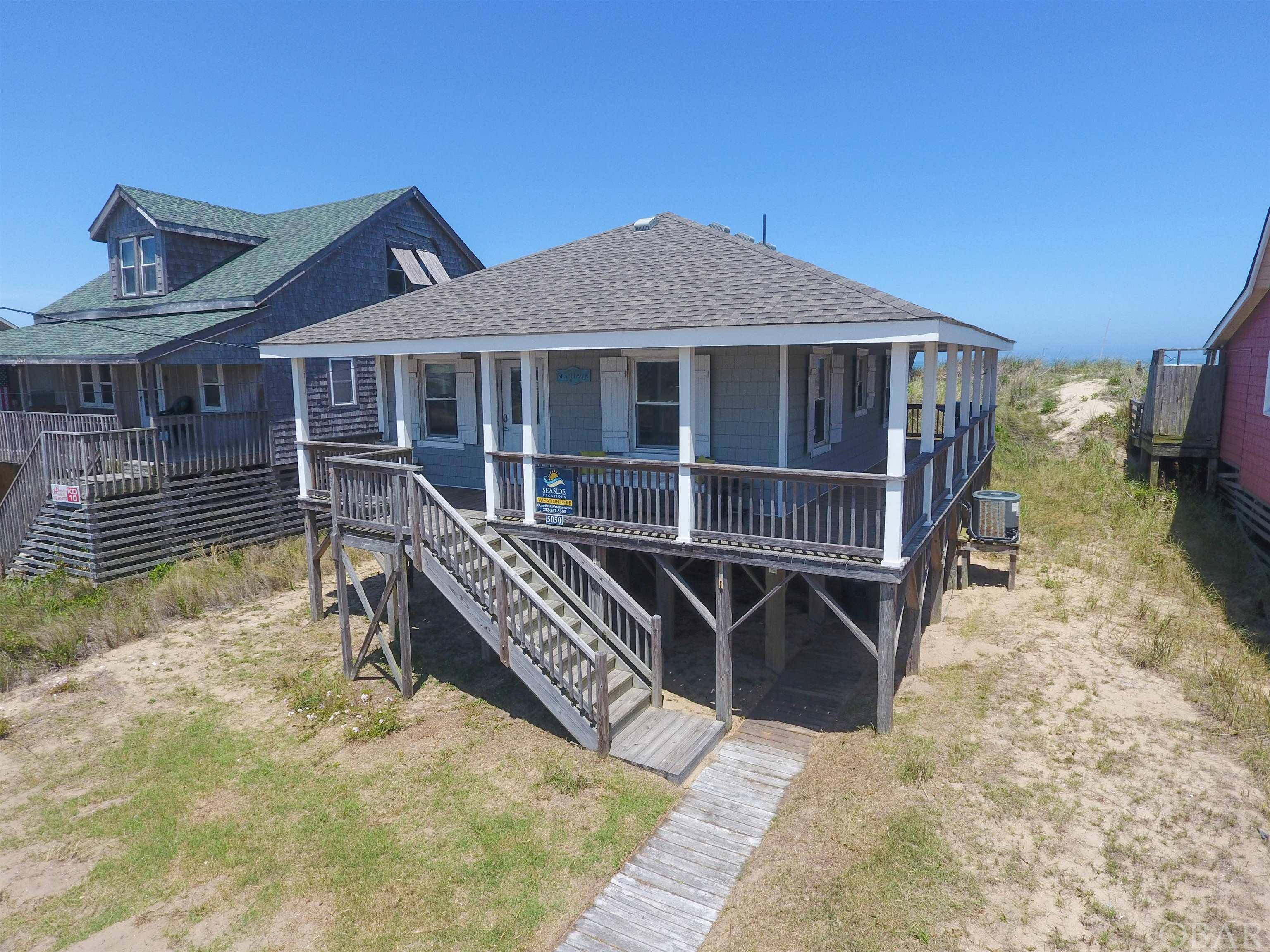 It doesn't get much cuter and quaint than this!  This classic OBX cottage takes you back to the time before the hustle and bustle.  The cottage has all of the original knotty pine tongue and groove paneling with it's stunning original pin flooring. The kitchen has been updated with soft close, high quality cabinets, granite countertops and stainless steel appliances.  This home sits on all new 8X8 pressure treated pilings, has newer underpinning, and a BRAND NEW ROOF (March 2022).  This little retreat would be a great investment or second home.  There is something peaceful about this little slice of OBX Oceanfront.  Wake up and watch the sunrise from your own porch, gaze at the surfers and fisherman doing their thing at Avalon Fishing pier.