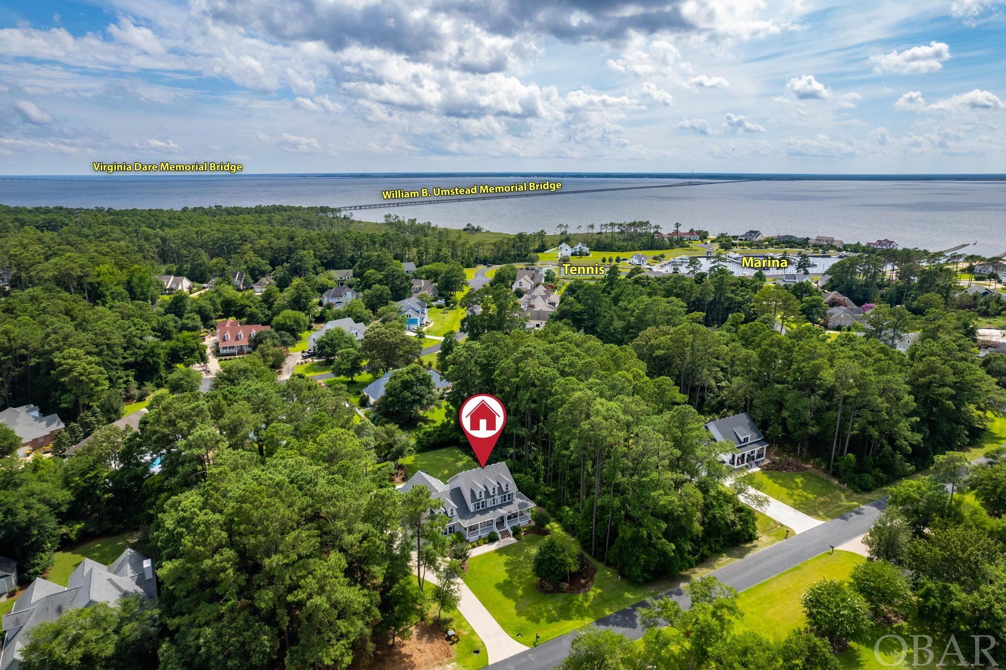 Presenting a true champion of quality in this 100%, Turn-key Heritage Point home located at 112 Weir Point in the quiet North End of Manteo NC. It’s exquisite appeal and design were Engineered with a mindset of creating a home of absolute efficiency and quality with a flair for perfection in every step you take. A 2015 build by renowned Manteo builder Bobby Etheridge may as well be 2022 as the standard of maintenance and care is astounding from the Floors to the Ceiling. 2x6 walls, Fiberglass Vinyl clad doors & Windows, PVC trim…the list goes on. The Curb appeal shows the meticulous nature of the owner’s daily care, with Irrigated Zoysia Sod and curved flower beds commanding your attention all while accentuated by a brick edged walkway with Native plant species. The Exterior of the home is luxurious in all aspects with Carolina Beaded Vinyl Siding, Radiance Timber tech rails, Trex decking and Fiberglass Columns creating a beauty that flows effortlessly from the covered porches into the Grand entry. The custom Thermatru three-tiered door, with Transom windows and Granite etched glass opens into a vast two-story entry with an open Foyer. Gravitating to the Old Towne Hickory hardwood, the incredible floor has rich character and is accentuated by the homes soft palette of inviting wall colors. This home is inviting and the floor plan was designed for open flow and comfortable living while keeping Natural light at a maximum in all of the Simonton Platinum tilt windows. The large living room offers a Gas Fireplace and built-in shelving, beaded back board and custom window seats. Craftsman trim work includes 6” crown molding, encapsulated bead board, wainscoting and intricate patterned woodwork that adorns the entire home. Look into this dreamy Kitchen with Custom 42” raised panel slow close cabinets, elevated Granite counters, Commercial gas stove, SS appliances and cabinet space for a large family. Functional beauty that bleeds over into the sizable stylish dining room. A groovy nook off the Kitchen is sure to be a popular spot for breakfast and reflection. The large En Suite has vaulted ceilings, Walk in closets and a bathroom fit for royalty with a walk in shower and stylish design. A Powder room, Utility room with sink and access to the huge 2.5 car epoxy coated garage finish off this level. Upstairs offers more flow with gorgeous picture windows creating ambient light over the wide hallways that flow into the 3 additional bedrooms, Full-hall bath and huge Multi-purpose room/Fifth bedroom with walk in closet/gym area. This space is the secondary living large family dreams are made of. A meticulous home with stylish features and grand living all finished with an Eight-foot Anderson rear door leading you into the rear covered and screened porch overlooking a backyard Oasis. A Brand new oversized concrete pool offering a heater and tanning ledge is out of this world. Finish the evening with an LED lightshow. The pool offers a smart control system, robotic vacuum and safety cover for ease of use. Rear Landscaping inspires the mind and has plenty of room for everyone including your four legged friends! Heritage point community offers a deep water Marina and a Boat slip for each owner with shore power. Top that off with tennis courts, workout space, a true Sound beach with Gazebo and Pier all overlooking our famous Outer Banks sunsets! Exquisite home in a Coastal location with amazing amenities make this the best Manteo home on the market. Stop what you are doing and make dreams a reality. This is a story worth creating and your mark is all that’s missing.