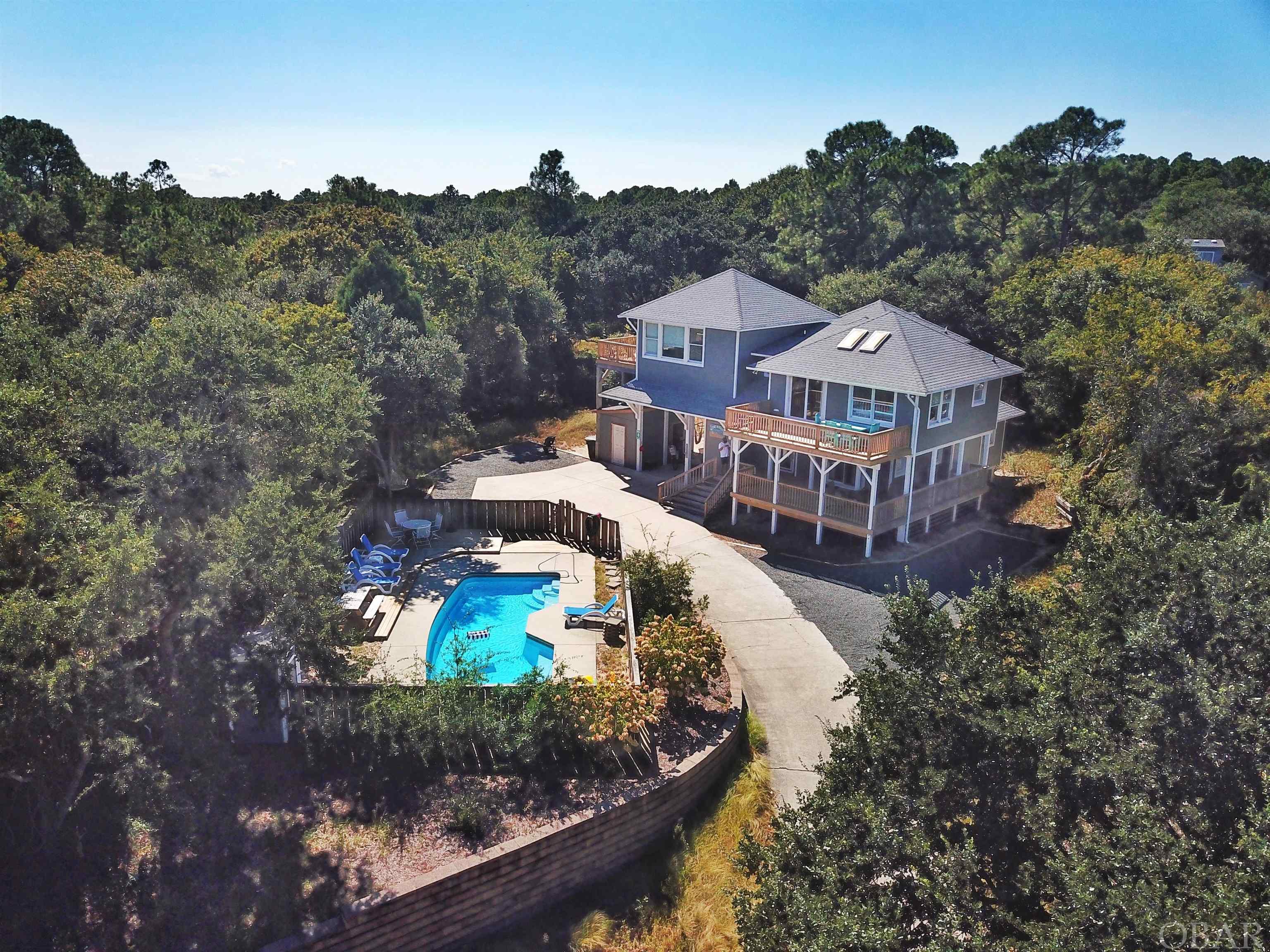 **OFFER DEADLINE: August 22, 2022 at 12 pm - Highest and Best ** Don't miss out on this Southern Shores gem.  Walking distance to Hillcrest Beach access with a stoplight and crosswalk.  This home features a private pool on an expansive mostly cleared lot but tucked away from the street with beautiful live oaks surrounding the property.  5 bedrooms and 3 bathrooms on the first level, with the second level having a primary suite and en suite bathroom, a half bath, a spacious kitchen and dining room, from the dining room you walk past your bar area into the elevated living room with slight ocean views over the trees.  There is plenty of deck space and outdoor space for the whole family to enjoy!  There are two storage sheds outside for all your owners and beach storage needs.  The private pool is situated high on a bluff with potential to add a pool house or garage out front (buyer agent to verify with town of SS)   This home is currently used as an Airbnb in the summer months and some shoulder season dates. 2022 has over 91k in booked rents with numerous weeks blocked in fall for owner. Prior to sellers purchase, this was a gently used second home.  Last fall , seller used home for most of September and did close to 10k in rentals in October / November. Don't miss this opportunity to own this great rental house, primary residence, or second home!  Schedule your showing TODAY!
