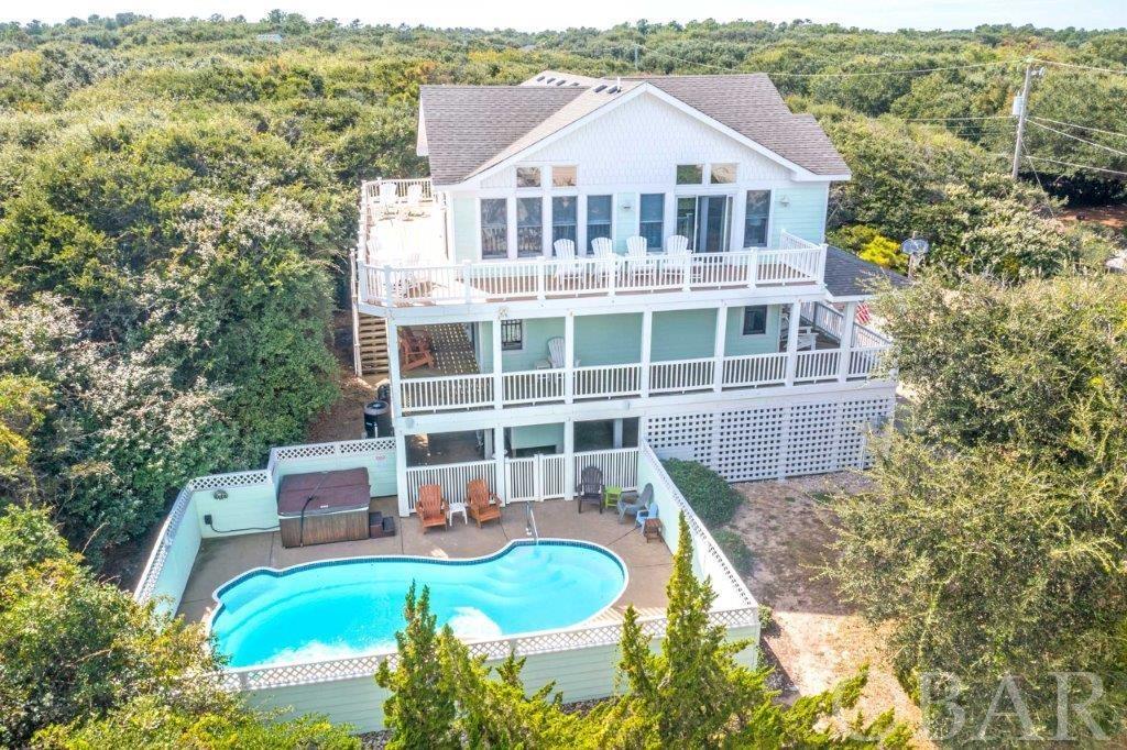 YOU WILL LOVE THIS SOUTHERN SHORES HOME - "BEACH BELLA" It has it ALL! ... ELEVATOR, POOL, HUGE GAME ROOM, AND MORE! Located Just 2 Lots from the Community Oceanfront Beach Access! Cross over Ocean Boulevard at the very visible NCDOT CROSSOVER - so traffic stops for you to cross ... Altogether maybe a 4-Minute Walk to Toes in the Sand & Surf at your Feet! *** The Design maximizes the home's location and even though you are so close to the Beach you also have Great Privacy! * Plenty of parking for vacationers but that also makes it easier for when you want to have Family & Friends stay for a visit! *** The Top Level 3 Features the Main Great Room w/ Volume Ceilings with Built-In Surround Sound Speakers and loaded with can lights for great lighting, plus the window array provides great Natural Light as well * The Living Room Features raised hearth Gas Fireplace, Open Dining - plenty of seating at the table & at the Kitchen Center Island * The Kitchen is open to the Great Room so anyone working there can stay a part of the Fun happening around them * Double Dishwashers for when there is a large group * Sliding glass door out to Top Level South & East Decks - Overlooks the Pool & a Peak at the Ocean! (NOTE: Build a Roof Top Deck to capture some awesome Ocean Views! Research the possibilities!) * On this same Top Level 3 there is a Main En Suite Bedroom w/ Large Bathroom * Office Desk Space, Powder Room for the Great Room & ELEVATOR (which does go to all 3 levels!) *** Mid-Level 2 Features 4 En Suite Bedrooms - so each has its own Full Bath! * Extra Large Main Entry Foyer and well-designed Hall area * The Mid-Level also Features a Covered Sun Deck on the South & East Sides *** Ground Level 1 Features a "HUGE" Game Room with a Pool Table & Foosball, Powder Room, En Suite Bedroom with its own Full Bath! Sliding Glass Door out to the rear Grilling area and to the Outside Shower / Pool Area, ... or there is a Carport Door Entry into the Game Room through which you can also access the Outside Shower & Pool *** Big Carport with lots of covered area! NEW Pool Heater *** "X" Flood Zone so NO Flood Insurance required *** Home is perfectly situated for use as a Primary Residence - quiet / private and close to the Beach *** Or, would be a great Second Home! ... Or as it is now ... a Perfect Vacation Rental / Second Home! *** Offered Fully Furnished & with ready Rental Income ... Rental Gross $80,000 Range! *** The Community & Area Features - Southern Shores has a voluntary Civic Association at $65yr, and you can join the Boat Club for $25yr and Tennis $25yr * Boat slips additional * You will have access to multiple beach accesses - including the Hillcrest Beach Access w/ approximately 60 spaces, outside showers, dune gazebo & deck looking out over the Atlantic Ocean, volleyball court, seasonal facilities, and lifeguard in summer * 3 Boat Marinas, Boat Ramp, 2 Soundfront Beach / Parks - great for Sunsets w/ wine & Cheese * Town Sidewalk along entire Ocean Boulevard & Duck Road - miles of biking/walking in Southern Shores * The Duck Shops and Restaurants are just minutes way - check out the Duck Town Green & Soundfront Boardwalk * Additional Area Attractions include the Corolla Lighthouse, Wright Brothers Memorial, Jockeys Ridge & much more *** Kitty Hawk Elementary School is just minutes away! Easy access out to the Wright Memorial Bridge* Great Community & wonderful Neighbors *** A few Minutes' Walk to the Beach * Elevator * Heated Pool * Huge Game Room *** After a day at the Beach the Family can enjoy a Swim in the Heated Pool ... Check it out - the Pool Deck Features Speakers powered from the Game Room Audio System - you can Bluetooth stream your Music ... it will make the "Experience" a "Memory"! *** Offered Fully Furnished *** 2022 YTD Rents $80,066! ... and 2023 already has $61,040 Booked w/ Sun Realty Rental Company Projecting $102,816 possible! *** This Home has the right Features and Design ... You will love it! ... Come See!