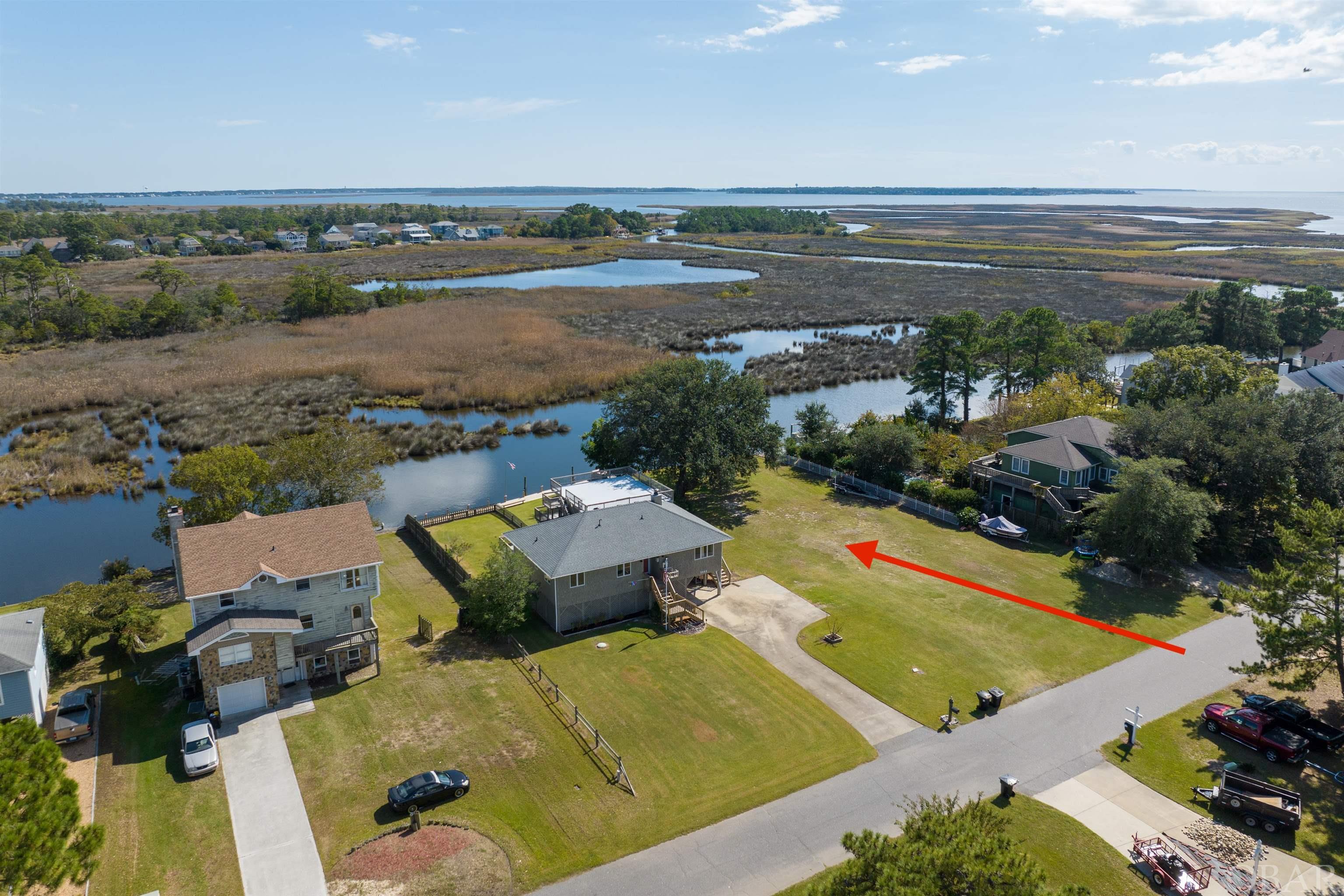 Fabulous, canal front lot in Kitty Hawk Landing has been cleared, filled, bulkheaded and has a jet ski lift. This location provides fantastic views of the sunrising over the marsh. Kitty Hawk Landing has deep water canals leading out to the sound for your boating pleasure and private, deeded beach access with bath house. It feels private and tucked away while providing easy access to shopping and restaurants via The Woods Rd or Kitty Hawk Rd.  Check it out today!