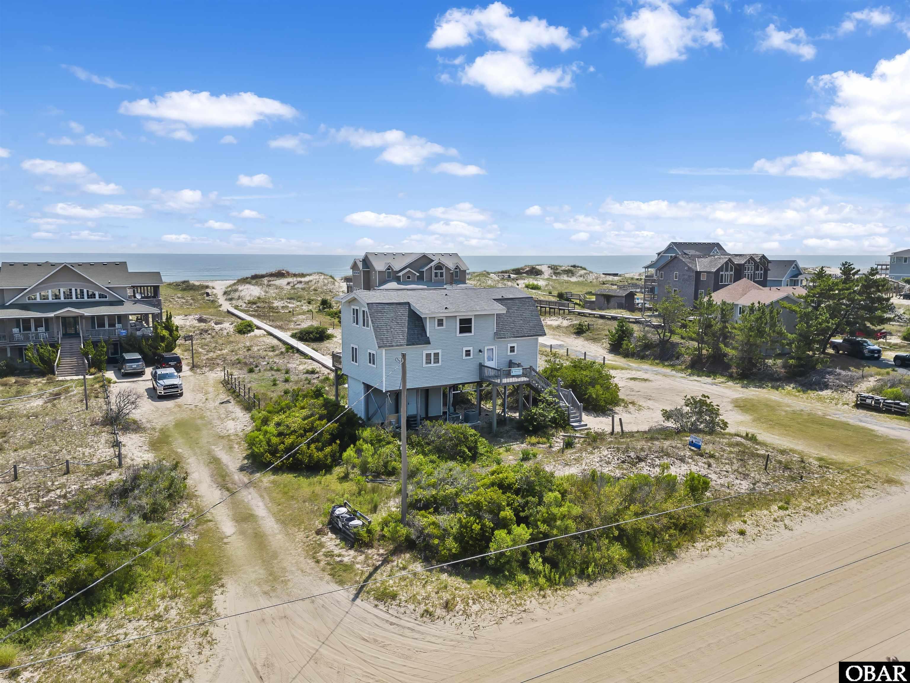 The lowest priced oceanfront house in the county! Brand New Fortified Roof just installed this year. Looking for the ultimate beach getaway that won't break the bank? Look no further! This charming and cozy oceanfront cottage is the lowest priced in Corolla, making it the perfect spot for smaller families to enjoy. With yearly rental income averaging around $90,000, you can offset the costs of owning a beach house while still getting to enjoy it yourself. Boasting three bedrooms, two full bathrooms, and plenty of warmth, this cottage offers all the charm and comfort you need. The open living room and dining area, as well as large, bright bedrooms, add to the appeal. Plus, with private beach access via a newly redone boardwalk, you'll be just steps away from the sand and surf. And with plenty of room to add a pool and other amenities in the back yard, you can truly make this your own oasis. Watch the wild horses graze in the yard from the back deck - guests have reported seeing them almost daily. With a strong rental history and all the amenities you need, this may be just the escape from city life you've been looking for. Don't wait - act now!