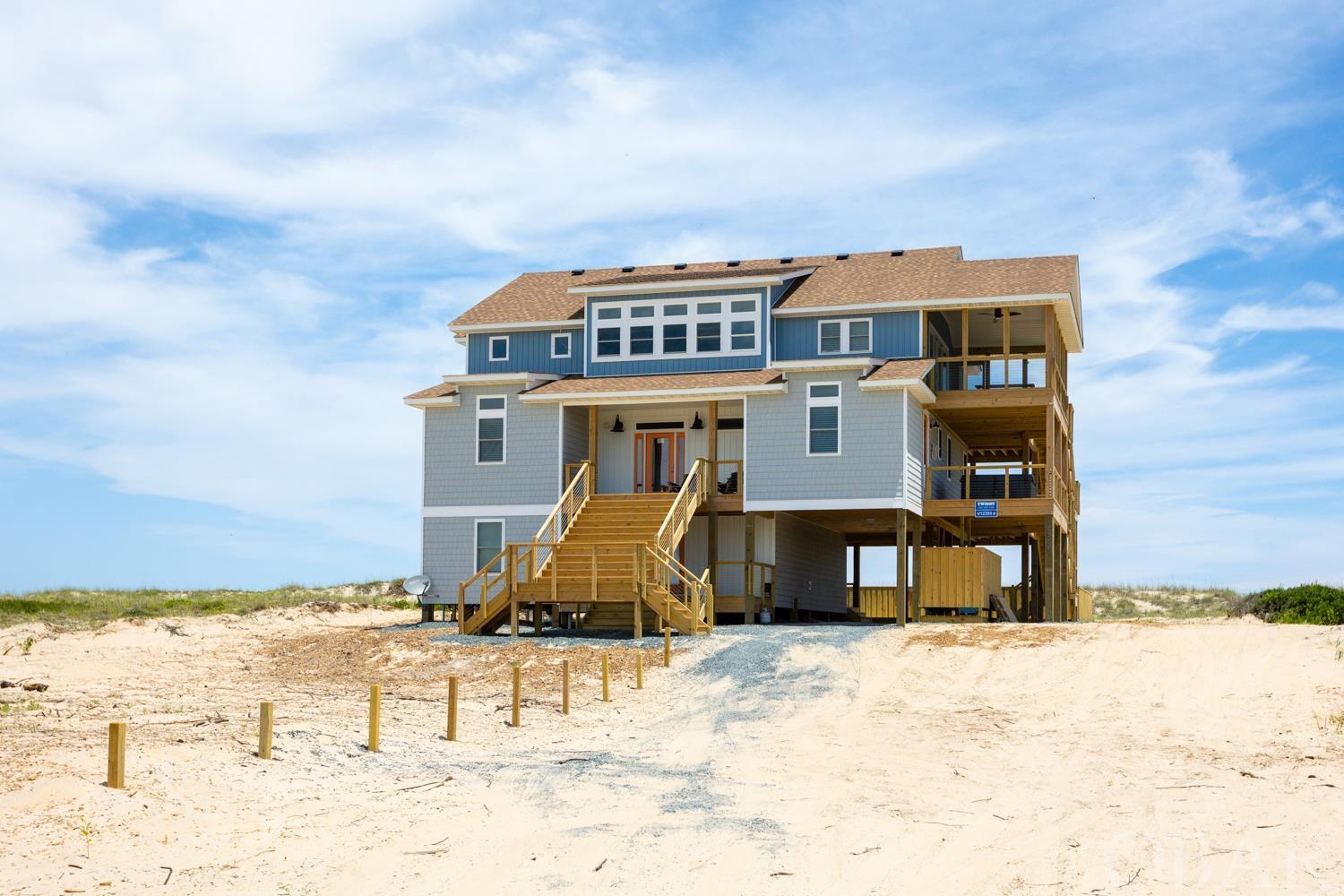 Approximately 10.3 miles up the beach. This high end new construction 6BR/6.5BA oceanfront is spectacular!  After a day of fun in the sun, relax and unwind at Apres Sea! Located oceanfront in Carova on the 4x4 beach, you’ll find secluded solitude. The ocean backdrop is present from the oversized decks that feature wire railings for picturesque views.  Level three of the home features an open-concept kitchen with two dishwashers and two refrigerators. The living area overlooks the ocean and provides a cozy place to gather with family around the electric fireplace on cool evenings. A spacious dining area can be found both indoors and in the screened-in portion of the deck. The master bedroom boasts a grand soaking tub and a sitting area overlooking the ocean. Four master bedrooms on level two all have deck access so you can enjoy the sea breeze from any level of the home. The hot tub is located on the covered deck so you have a warm and relaxing place to take in the scenery during any type of weather. Level one provides a space for entertainment from the theater room with tiered seating, to the rec room that features a pool table and bar!  The fun continues outside to the pool area that’s outfitted with an outdoor bar perfect for poolside cocktails. The backyard space has its own outdoor bathroom with a shower so you don't have to miss a minute of sunshine. Apres Sea provides the ultimate place to relax and keep the good times rolling from beach days to nights at the pool and everywhere in between!