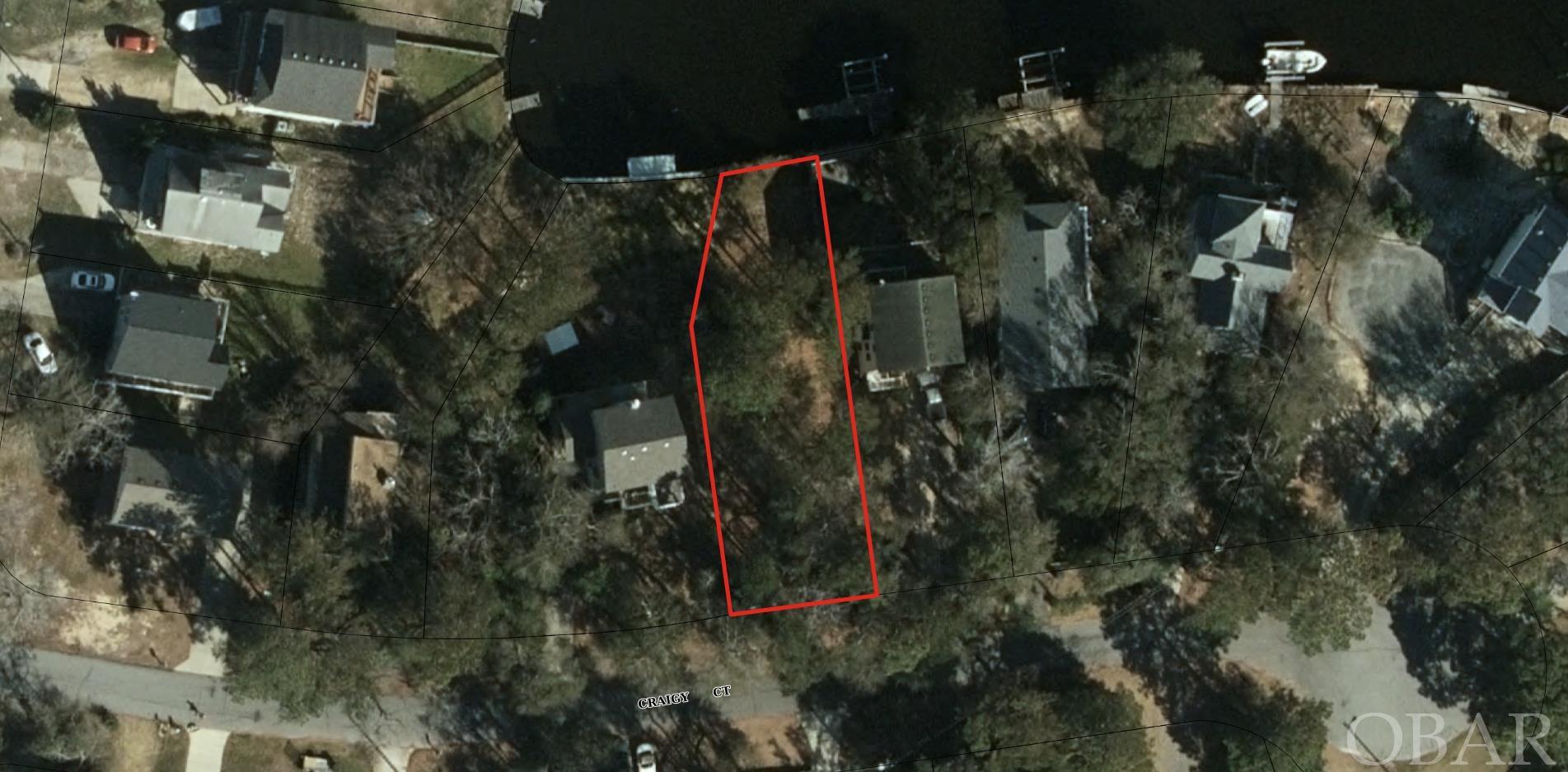 Rare & affordable Canalfront lot available within the gated community of Colington Harbour.  Stake your OBX claim with this elevated homesite, on a quiet low / no traffic cul-de-sac, in a natural treed setting, offering 32' of water frontage. Average elevation at the building pad site is 11', see recent survey, available to buyer at no cost. Colington Harbour is an active community, with amenities that include a Community Clubhouse, marina, boat ramp, Olympic size salt-water pool, baby pool, tennis, and a soundfront park area with a beautiful sandy swimming beach. Lots to do here...sandy beach, community pool, boating, kayak, paddleboard, and direct access to the Albemarle Sound, and beyond. Great year round, or second home location, and water frontage and community amenities offer rental potential if desired. Take advantage of new, improved building materials to build a brand new custom home to your liking, for low maintenance and ease of ownership.  Colington Road improvements and bike path to be completed soon.  Few OBX homesites are available, especially for waterfront / water access, act now to secure your spot. Building information and consultation available.