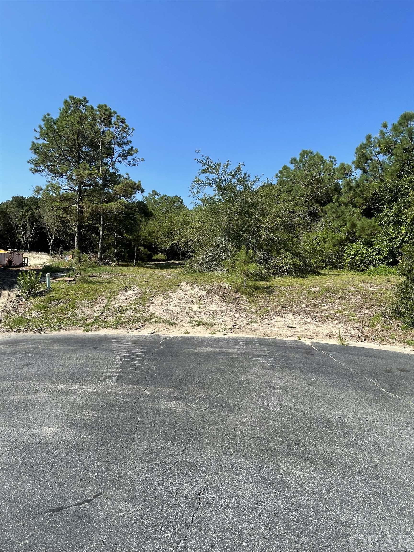 This is a high lot fully accessible from the Grouse Court Cul d' Sac. Prospects with Agent will have no trouble walking the lot. X FLOOD ZONE NO FLOOD INSURANCE NECESSARY . Very few home sites on this Court. Located close to the North End Pool One of Three on site. Children playground. CURRITUCK Clubhouse, THREE COMMUNITY POOLS, one a short walk for the family. Located in this TOP QUALITY GOLF COURSE. Plenty  of Walking and Bike Paths with Little vehicle traffic. Great place to build your retreat.  NOT MANY LOTS LEFT IN CURRITUCK. FREE BUS RIDE TO THE BEACH ALL SUMMER LONG. LARGE PRIVATE HIGH LOT.