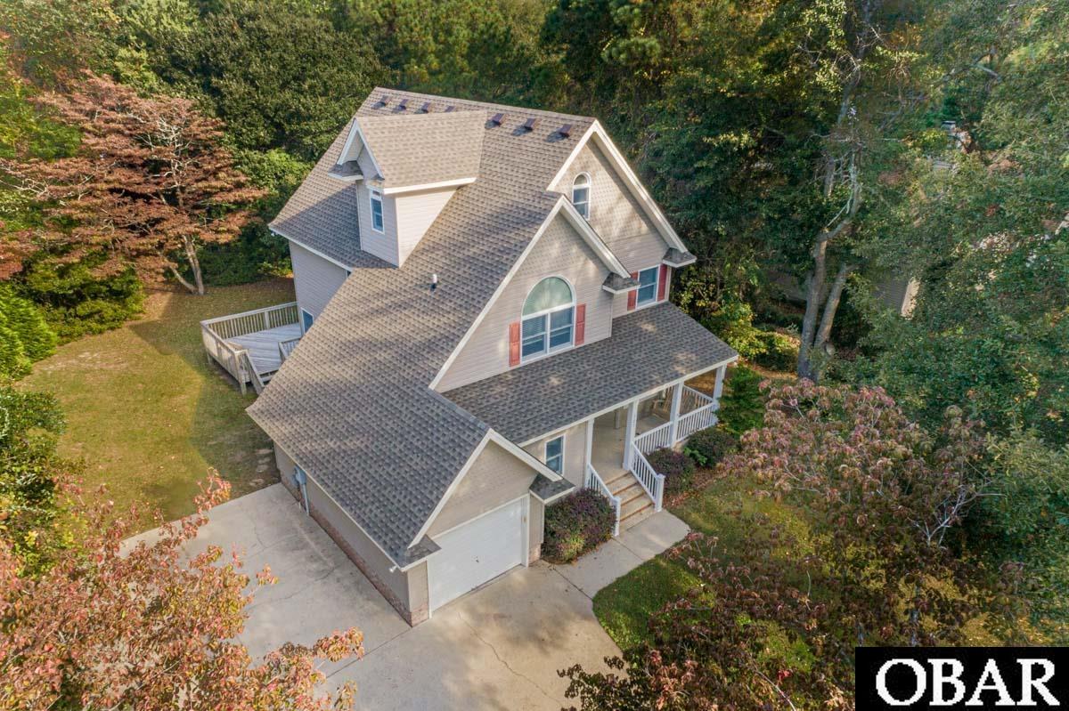 This Roanoke Island home has been very well cared for and offers 4 bedrooms, 2.5 baths, attached garage, lots of privacy and the added bonus of a community pool. Owners have made many recent improvements and updates including: new roof, HVAC, high efficiency water heater, professionally finished hardwood floors, interior paint and flooring (see detailed list in associated documents). The first level features a large kitchen with breakfast nook, generous dining room, cozy family room, separate laundry room, half bath and large sun deck overlooking private backyard with mature landscaping. On the second level there is a large primary bedroom (17' x 13') with ensuite bath featuring dual vanities, garden tub, enclosed shower and walk-in closet. There are 2 additional bedrooms and a full bath also on this level. The third level features a huge bonus/flex room that can be utilized as a 4th bedroom, guest/in-law suite, home office, craft room, theatre room or family recreation room. This neighborhood is the ideal year round setting; large private homesites, community pool to keep you cool in the summer and quick access to the municipal walking/biking trails that make getting to downtown Manteo a breeze. Come take a look at this charming home today!