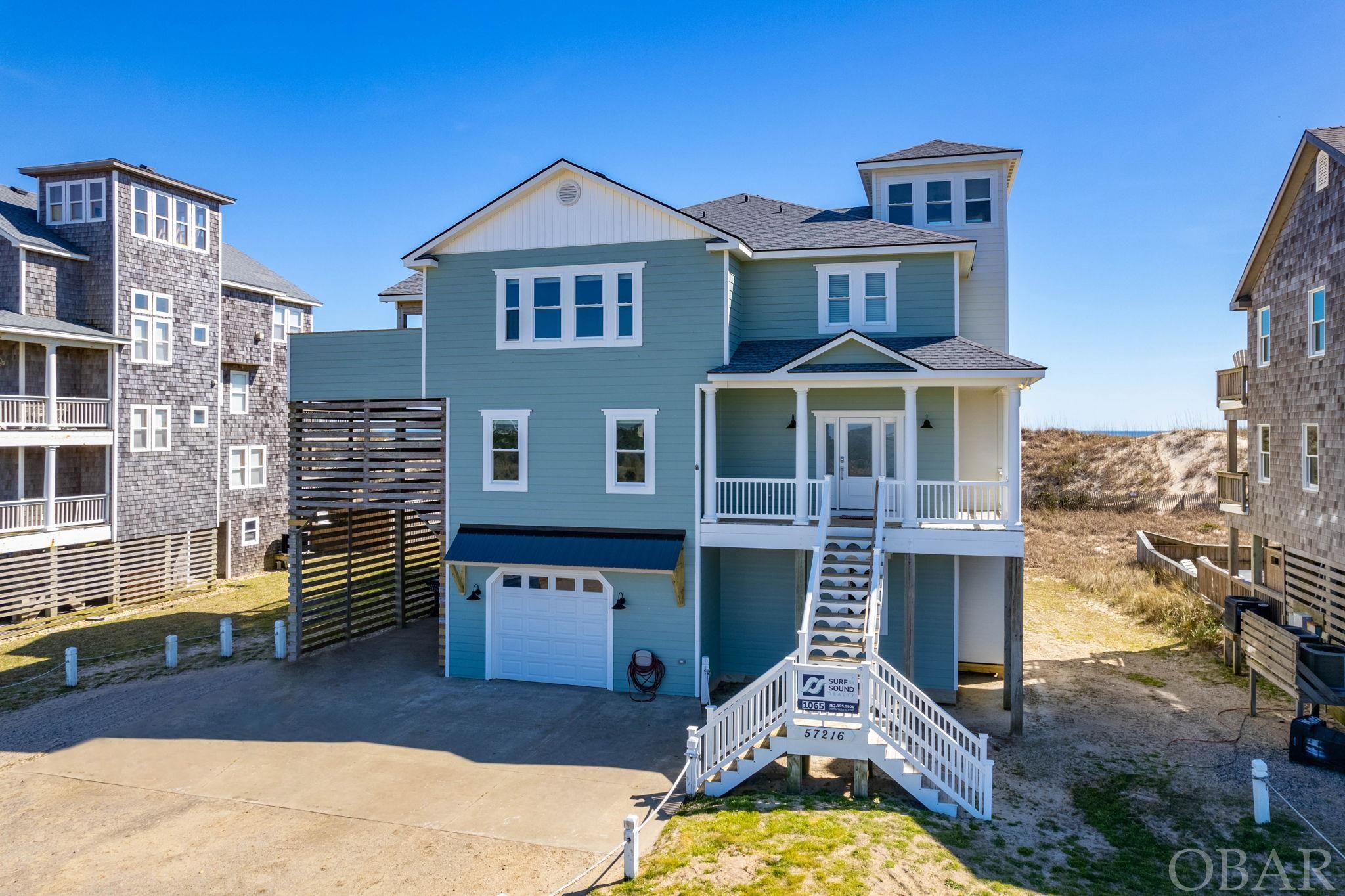 Experience the island life in real time - oceanfront and in the heart of Hatteras! This 7-bed, 7.5-bath home has been meticulously renovated from top to bottom and inside and out. The finished product is exquisitely appealing; no expense has been spared, ensuring that every detail hits the highest marks of quality design and craftsmanship. It is truly exceptional! Stepping inside, you're immediately struck by stunning views of the Atlantic no matter which way you turn. The expansive living areas have been designed and furnished with the finest materials by a professional interior designer, creating an atmosphere of pure luxury and sophistication. The transformation of this home is indeed impressive with energy-efficient windows and doors, updated exterior siding and an elevator recently brought up to the latest code. The pool area has been dramatically modified into a breathtaking oasis, complete with a brand new pool house pump, LED pool lighting, and a pool deck stained to perfection. Take a dip in the main pool or wading pool, or relax in the brand new 6-person hot tub while you watch the waves crash against the shore. Outside, you'll find a bar seating area with stools on the lower deck, perfect for entertaining guests or enjoying a cocktail while taking in the stunning ocean views. All of the deck railings have been replaced, and repairs to the floor decking have been completed, ensuring that the outside of the property is just as exceptional as the inside. A modern and stylish metal roof eave has been installed over the garage door area, and an electric EV charger in the open carport area. Inside, you'll find a fun-filled arcade room with a Pac-Man machine and a wet bar, perfect for enjoying a game or two with friends and family. The kitchen has been completely upgraded with brand new cabinets, polished granite counter tops, and new appliances, including two new induction cook tops along with the induction pans and cookware. The bathrooms have been transformed into relaxing spa-like retreats. This property truly has it all, including a brand new 50-gallon water heater, updated interior paint, and new carpet and engineered wood floors throughout. With jaw-dropping views from every spot in the house, this oceanfront property is the epitome of luxury living. Don't miss out on the opportunity to make this exceptional property your own.