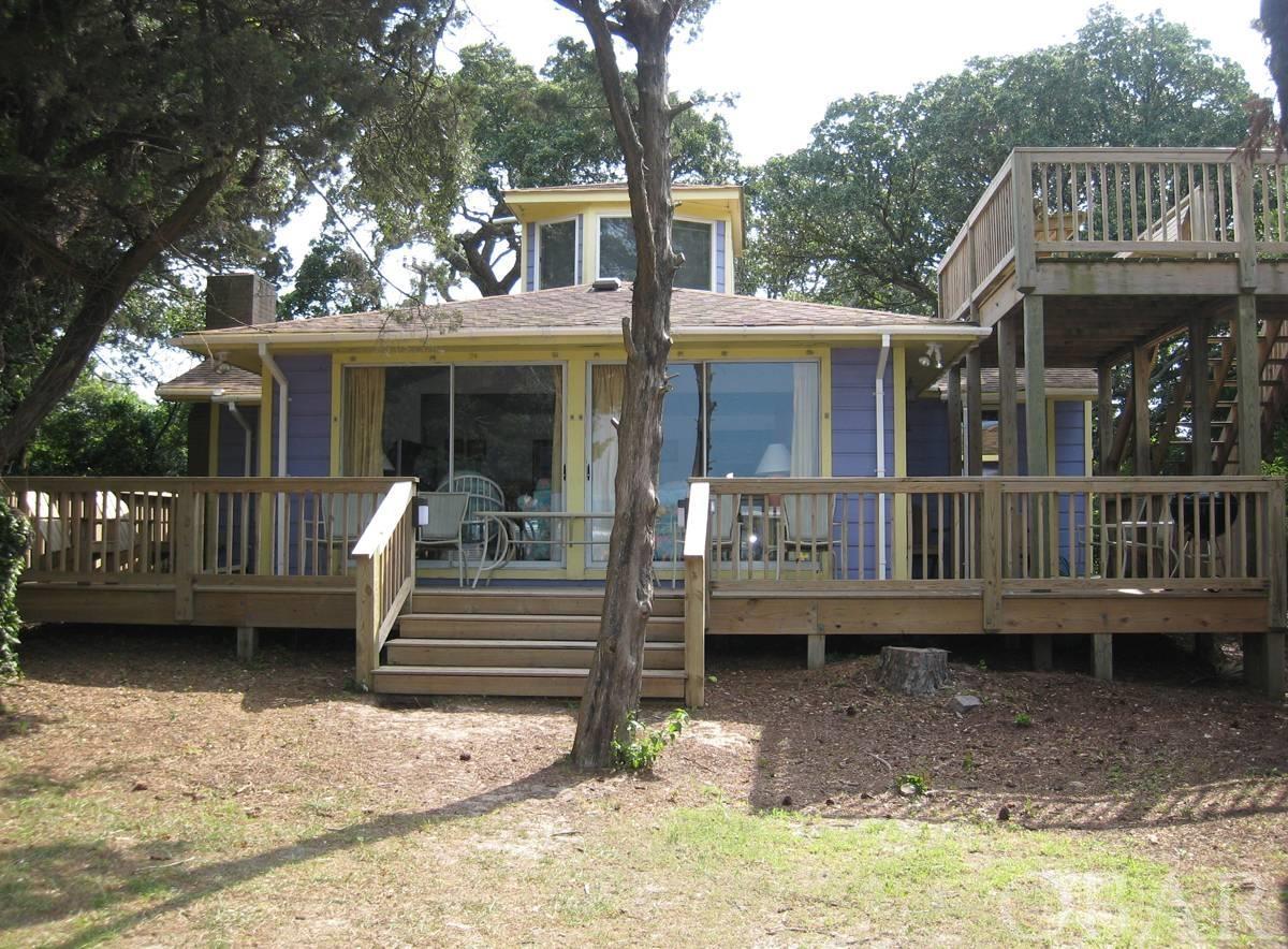 Views, views, views! One of the most coveted locations on Ocracoke, conveys with your own private dock on Silver Lake! Spectacular views from the open kitchen/living/dining area! Nestled between Hwy 12 and historic Howard Street, under a veil of mature live oaks, you'll experience the way life was intended. Watch the boats come in with their daily catch, arriving and departing ferries, glorious sunsets, kayakers, sail boats and water enthusiasts. 4 bedrooms (3 on first floor, 1 sleeping area in second floor cupola), central heat/ac (first level), mini-split for cupola, wood, tile or luxury vinyl flooring throughout, roof top deck with seating, partially fenced yard, kitchen with high ceilings and unique windows, living area with several sliding glass doors to maximize the views, gracious grassed waterfront fenced  area for a picnic, small gathering or a prepping space for a day on the water.  Upgrades in 2022: linens, living room furniture, beds, TV's, septic work, interior painting, outdoor shower, blinds, lighting, ceiling fans & new owner suite plumbing and bathroom flooring. Proven rental history!