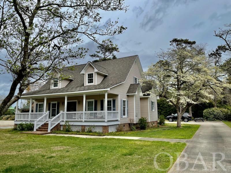 Desirable northend of Roanoke Island! Property fronts multi use bike path so you can enjoy a stroll or bike ride on a beautiful tree lined path! Home is well cared for with nice newer hardwood floors in livingroom, dining area and master bedroom. Master has his and hers closets. There are three bedrooms upstairs and one of them is huge! Lots of storage room in this house. Owners have already paid for water tap so you can hook up to city water! Large two car garage and lots of parking area. There is not only a huge covered front porch but also a screened in porch off of kitchen at rear of house. List of appliance replacements and upgrades are in Assocated docs. Exterior rear entry door to garage just replaced last week.