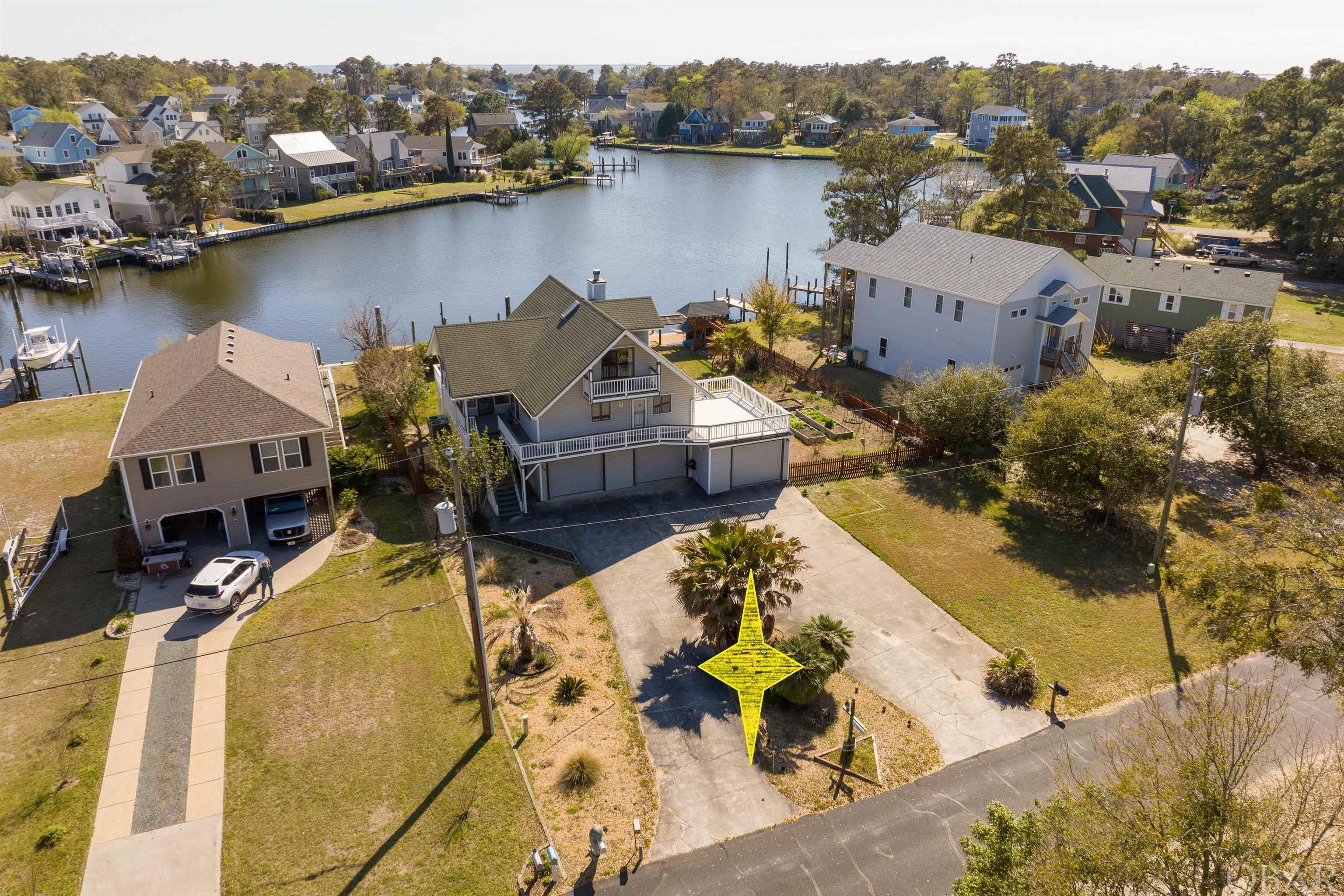 This magnificent custom built home is situated on two lots, fronts big water and is truly a boaters paradise! There is a boat lift, boat dock, floating dock for canoes & kayaks and a boat slip which will accommodate a 40' trawler. Enjoy a 3-car garage to store all your vehicles, small watercraft and an endless supply of equipment & accessories. With almost 15,000sf of waterfront property, there is plenty of room for gardening, growing fruits & vegetables, all within a mature fenced & landscaped yard with a variety of Palms, fruit trees & assorted plants. Decks and porches wrap entirely around the home with almost 1000sf of open decks, including retractable awnings in strategic locations. A 16x10 screened in porch with tile floors is great for sitting & eating outdoors. Covered entry plus a dry entry with interior stairs accessed through the garage. Additional features include a new 50 year bulkhead in 2020, LVT flooring installed in 2022, 50 yr Timberline roof shingles in 2007, new septic field in 2016 plus Trex decking, seamless gutters, Anderson sliding doors & water heater all recently completed. Original owners selected this ideal location to take advantage of the southwest breezes, the wide section of canal for great views and an easy boat ride out to the sound! This unique Chalet style home was custom designed, built with quality materials and features huge roof overhangs for shade and opening windows. Storm shutters are easy to install and will help provide peace of mind. One of the first homes on the street, this place has been well maintained over the years including numerous upgrades & improvements. Breathtaking views from almost every location around the home. A 2-zone HVAC system (new coils in '22) keeps the home comfortable in summer & winter, plus a gas log fireplace in the living room. 3BR 2BA in the main living area, there is also a finished bonus area on the ground level, partially heated with 3/4 bath, not included in the heated area. This space has tile floors and styrofoam insulation behind wainscoting. This property has so much to offer and one truly needs to see this home in person to appreciate all the wonderful features it has. If you have been looking for a waterfront property, then this just might be the one!