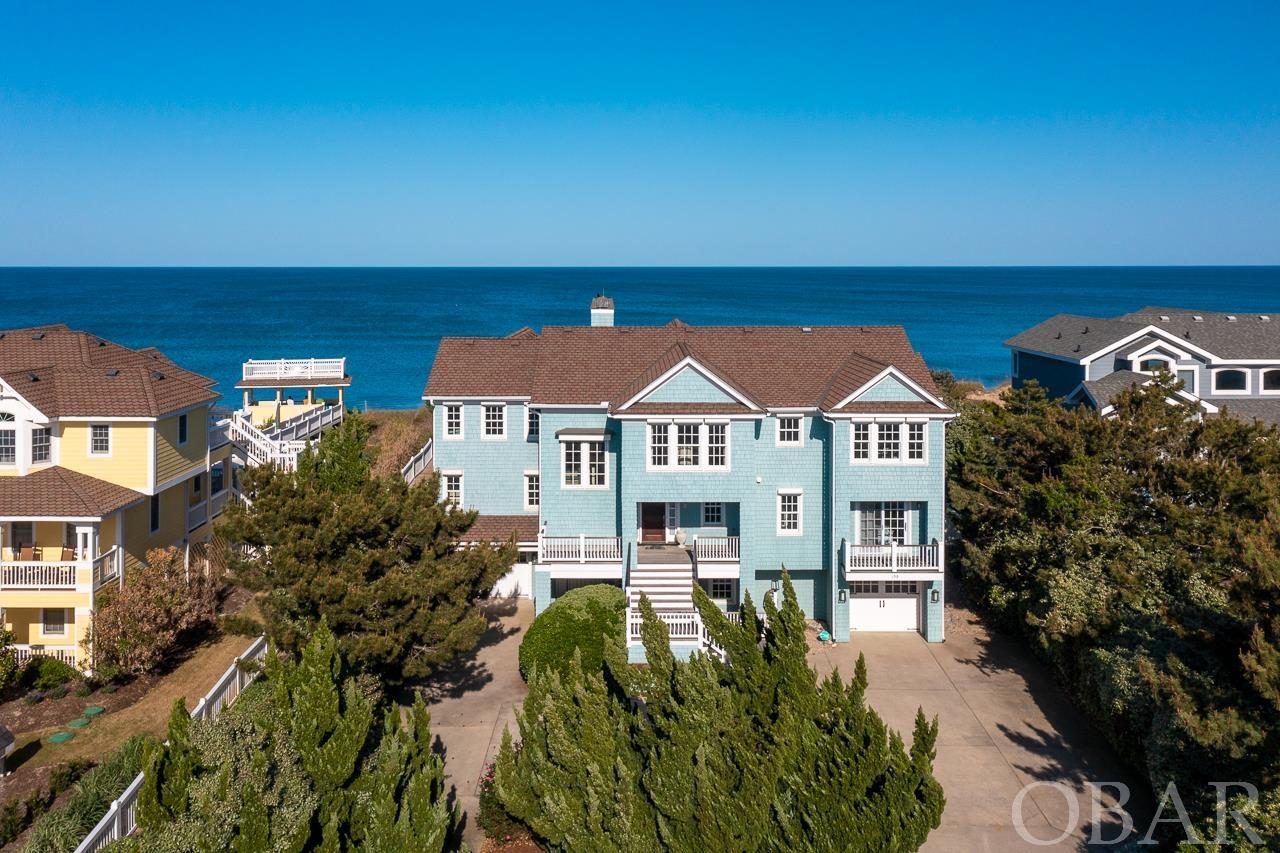 Extremely rare opportunity! This magnificent home is 1 of only 10 oceanfronts located in the prestigious highly amenitized community of Four Seasons. This lot is private, surrounded by tall vegetation located in the desirable Village of Duck. This home was built by one of the OBX's best builders and has never been rented! To say this home has been meticulously maintained is an under statement, there has been a caretaker/maintenance person in place for the entire existence of this home that contains everything you could imagine. There is a gigantic kitchen with a Sub Zero fridge, Dacor gas stove, a butler's pantry, multiple sinks, bars and plenty of seating. There are 6 bedrooms, 4 are ensuites, there's an elevator, game room, second family room with kitchenette,  heated salt water pool (that can be controlled by your phone), hot tub, steam shower,  2 fireplaces - one propane, and one wood with propane assist. There's a whole house water treatment system with chlorine removal and reverse osmosis water for drinking and ice. The entire house was custom curated - all custom finishes and high end designer pieces. The sectional, chairs and dining room window treatment are custom with a Jane Churchill fabric from England. The chandelier and sconces in the stairway were custom-made as well.  Opportunities like this don't come around often - don't miss this one! Updates include: 2022 - pool controller; 2020 - backyard zero maintenance grass & fence, pool heater, spa heater; 2017 - 2 Navien water heaters; 2016 - pool & spa re-plaster,  tile & coping; 2015 - screened porch, upstairs bath remodel, exterior paint; 2014 - all HVAC's; 2013 - beach walkway & dune deck.