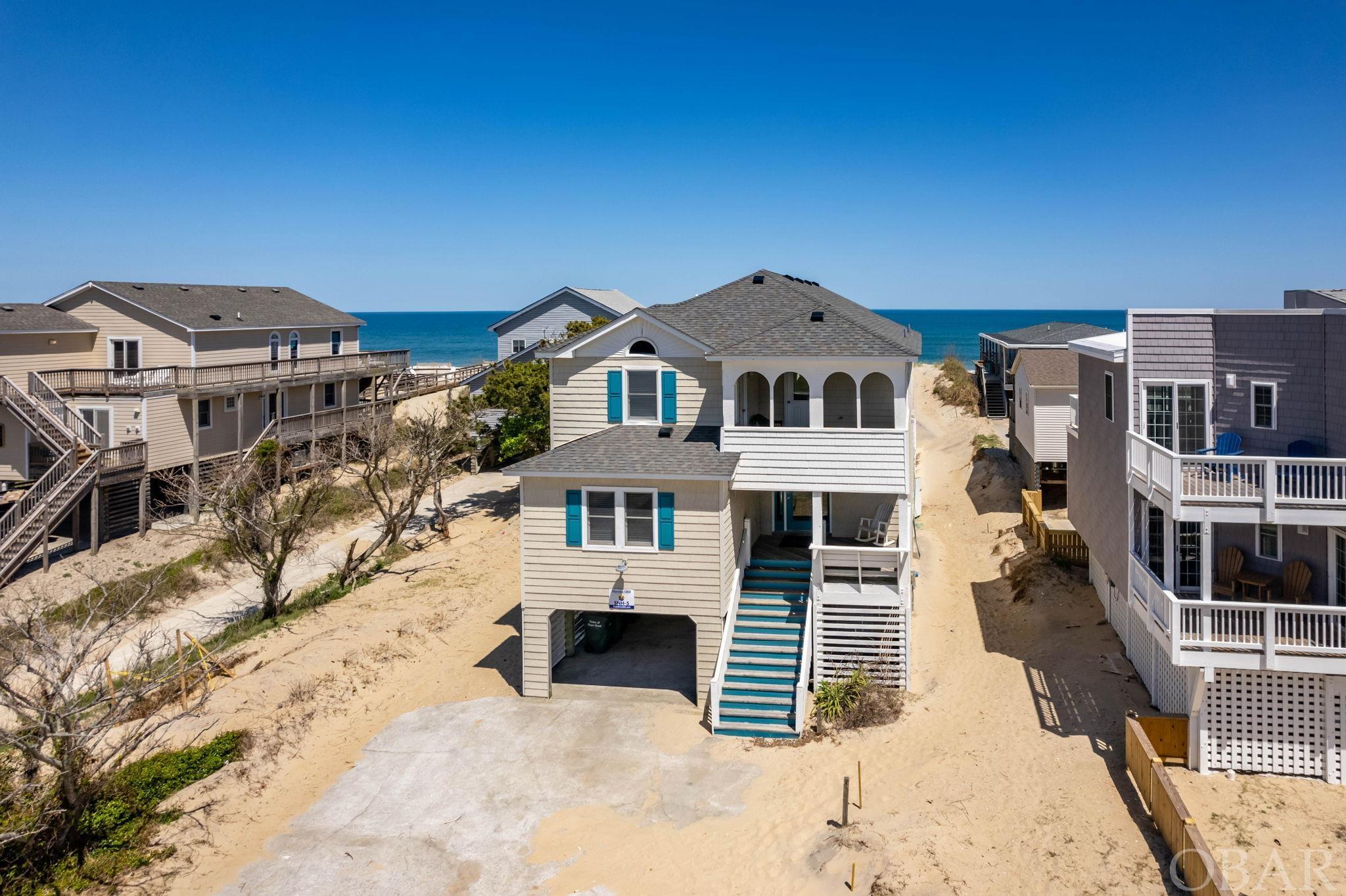 Welcome to your dreamy, not only updated, but upgraded oceanfront home in the heart of Nags Head! This stunning 8-bedroom, 5.5-bathroom coastal gem has everything you and your guests need, and want, for the perfect memorable vacation. Major repairs have already been skillfully completed making it essentially turn-key and more than ready to enjoy! With an impressive $203,668 in rental income in 2022, you simply can't go wrong!  Step inside and be captivated by unobstructed ocean views through the brand new windows. The top-level living room features new furniture, providing a comfortable and luxurious place to relax. The kitchen shines with granite countertops and stainless appliances, and there is ample dining and lounging space, including a breakfast nook with an extra refrigerator, a formal dining area and bar seating.  The mid-level deck, with a hot tub overlooking the pool and vegetated protective dune, is the perfect place to unwind after a day of exploring. Bedrooms are spacious and the layout is perfectly crafted for the ultimate vacation. Lower level features fully equipped game room with wet bar, lounging furniture and easy access to outdoor entertaining areas. The pool area offers just installed Trex decking system as well as a new pool fence and gate, comfortable seating throughout and a pool heater installed for year-round swimming.  Other recent updates include a new mid-level air handler system for improved climate control, and the septic tank has been raised and pumped in 2023, ensuring a hassle-free vacation experience.  Not only is this luxurious oceanfront vacation home fully updated and rental-ready, but it's also conveniently located near some of the best attractions in Nags Head. You'll be just a stone's throw from the famous Fish Heads Pier, where you can enjoy fishing, drinks and more stunning ocean views. Plus, with easy access to nearby restaurants and shops, including the Outer Banks Mall, you'll never run out of things to do during your stay. Whether you're looking to relax and unwind or explore all that Nags Head has to offer, this vacation home is the perfect base for your next coastal getaway. Don't miss it!  With all these updates and upgrades completed, this property is fully rental-ready and perfect for your next vacation. Don't miss out on the chance to experience luxury living in one of the most sought-after locations on the coast!