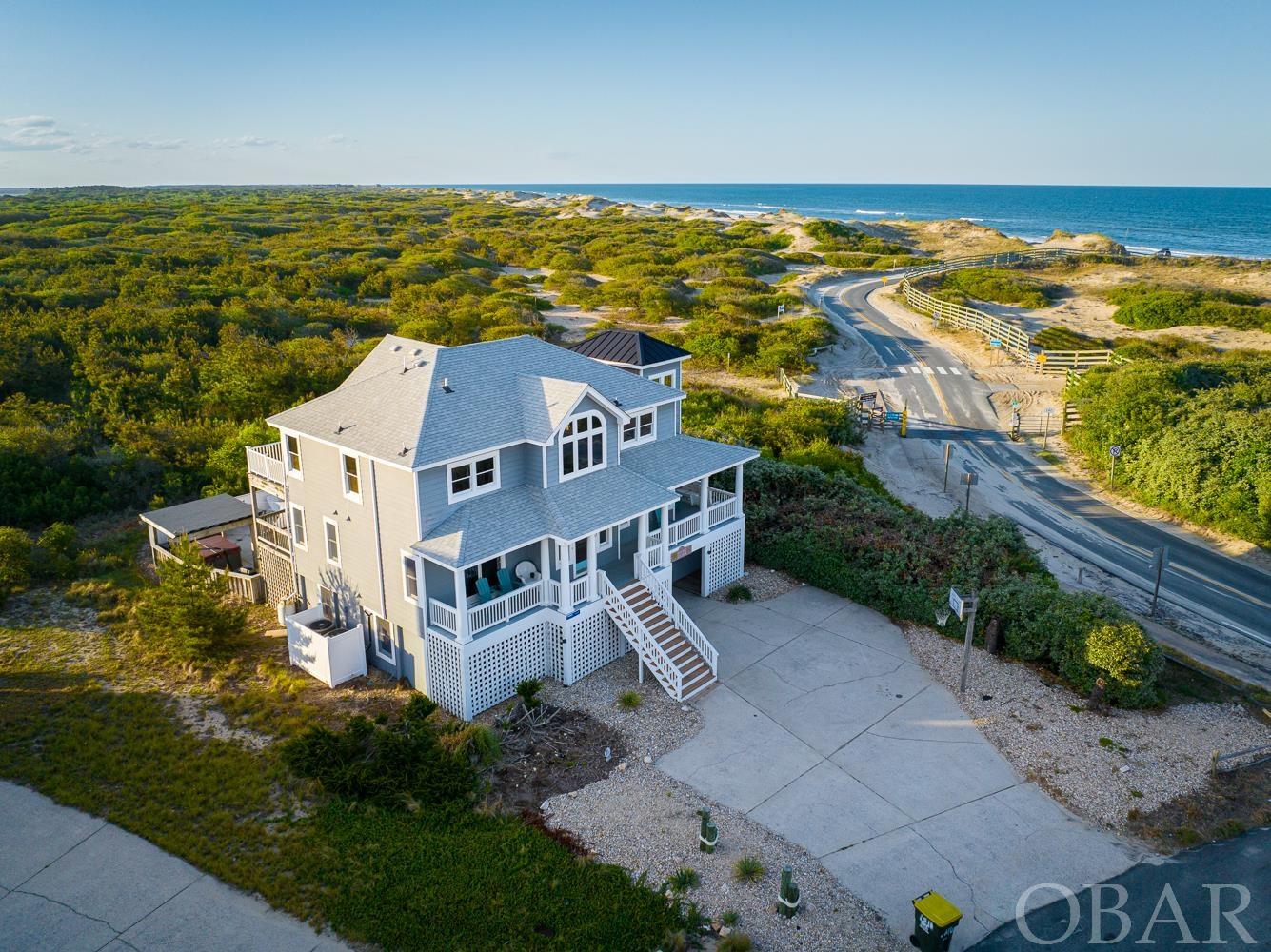 Updated with one-of-a-kind views! Welcome to “Double Anchor,” as one of the northernmost homes in Corolla Village, this unique 7-bedroom home in the Villages at Ocean Hill is located on the very north edge of Corolla's paved road, just before the 4x4 beaches. There is no 4WD needed to enjoy these scenic views, perhaps one of the many reasons why this home has been a consistent rental income generator, with over 140K on the books for 2023. As an ultimate coastal retreat, you'll enjoy overwhelmingly panoramic Atlantic Ocean views out of your back door, and privacy galore with the fenced in pool complex backing up to the wildlife preserve where the wild Spanish Mustangs roam. Easy and direct beach access is just steps away, and local attractions such as the Currituck Lighthouse, Corolla Adventure Park, shops and restaurants, and the Whalehead Club in Corolla Village are only a short bike ride or walk. The owners have taken meticulous care of this home, proactively updating all floors to either LVP, hardwoods, or tile in order to create an updated look, yet highly durable and easy to clean.  Soak up the sun in the private heated pool area or cool off and lounge beneath the shaded pergola. Several spacious decks equipped with poly-wood chairs and loungers offer plenty of space for relaxing comfortably outside. Designed with a reverse floorplan layout – these views are something you need to experience firsthand! The great room, updated kitchen, and dining are on the top level. The kitchen boasts stainless steel appliances and tasteful granite countertops. The top level is also home to a master bedroom with a new large soaking tub, perfect for relaxing after a long day on the beach. On the mid-level you’ll find four more bedrooms and a comfortable den, thoughtfully designed to add that extra multi-use space. The first level is equipped with a game room with pool table, wet bar and full-size fridge, and has direct access to the pool area.  A full bath and the final two bedrooms are also located on the bottom floor.  Recent major updates include:  New roof in 2021, New HVACs in 2021, updated bathrooms, landscaping, decking converted to Trex, siding updated, all new bed mattresses, numerous windows replaced, and upgraded pool area in 2022! Full list of updates/improvements available upon request!