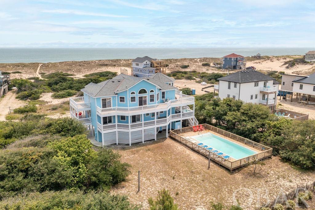 Enjoy the Outer Banks in this Semi-Oceanfront Beauty! This custom built home offers unobstructed panoramic ocean views! Located in Carova Beach, where the ''Wild Horses Roam''. There is over 4,100 sq ft of living space to enjoy family time at the beach! On the top floor you will find an impressive Octagon Ships Watch with hardwood, vaulted ceilings showcasing water views of the Atlantic Ocean. Along with a spacious kitchen & dining area, living room with fireplace, master suite with balcony, and a half bath. There are 7 Bedrooms total, with 5 Master Suites. 2 of these masters have whirlpool tubs to relax after a long day at the beach. You will also find wrap-around covered porches, massive sun decks, a mid level Media Room, & a Game Room with Wet Bar, & Refrigerator. Entertain in your Vacation Home in the Hot Tub and expansive 15' x 37' Private Pool. Make this your "Outer Banks Dream Home" today!!! Sellers limit rentals.