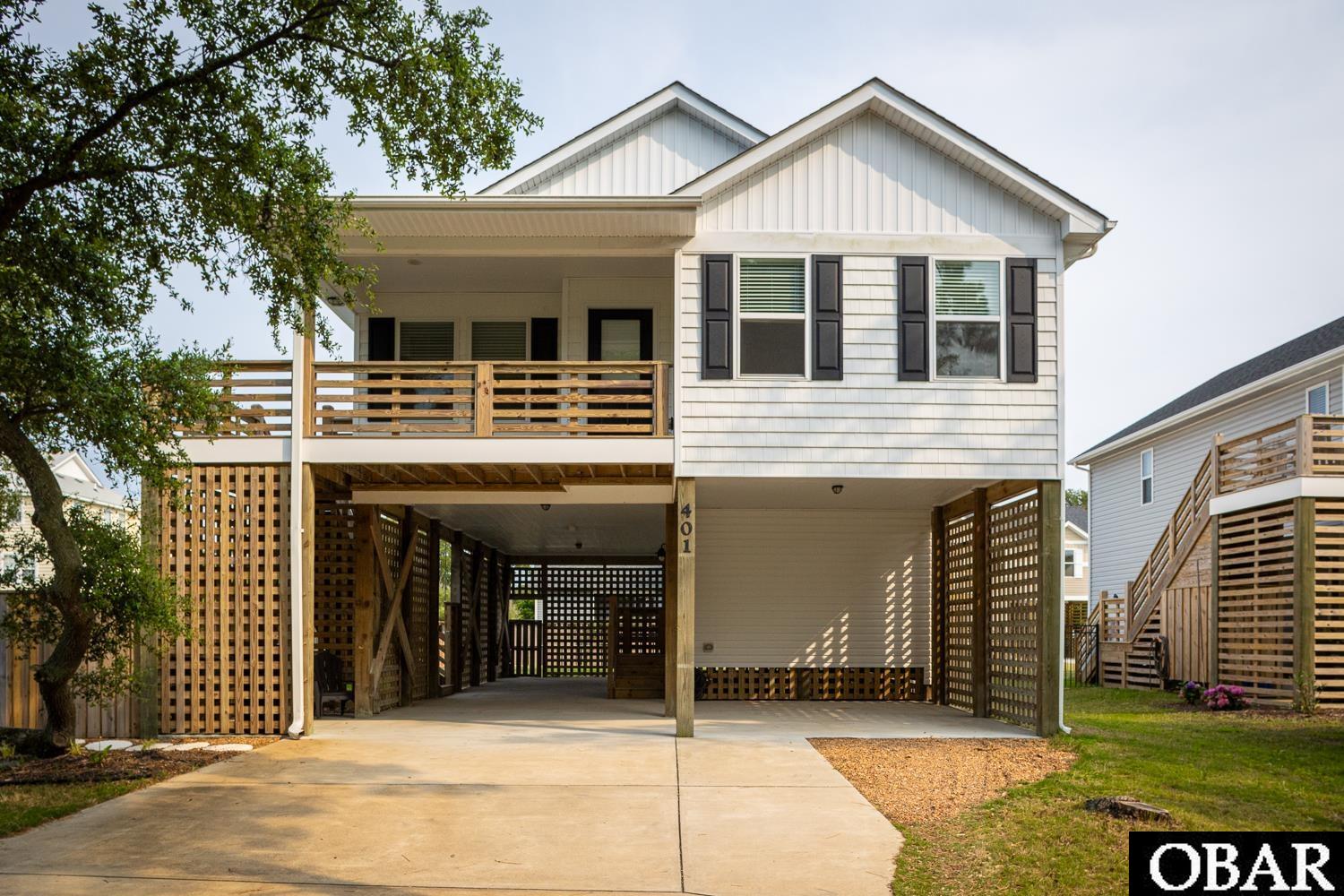 Just like new! Built in 2018, this 3 bedroom 3 bathroom home is in excellent condition. This home features a spacious floor plan with beautiful pine hardwood floors in the main living area and kitchen. The kitchen is complete with stainless steel appliances and granite countertops. All 3 bedrooms are located on the second floor just off of the main living area. The primary suite features vaulted ceilings with additional recessed lighting, walk in closet and a private bath with two sinks and tile shower. The first floor offers a large bonus space with full bathroom that could make the perfect game room, office or second living area. This home sits on a corner lot with a beautiful live oak tree in the front yard and a 6 foot privacy fence around the back and side yard. Underneath the home there is plenty of space for extra parking, storage or even a covered lounge area. This home is located in the heart of Kill Devil Hills with easy access to Bay Drive for gorgeous sunset views over the Kitty Hawk Bay. It is also conveniently located to many shops and restaurants and is only a 3 minute drive to the beach!