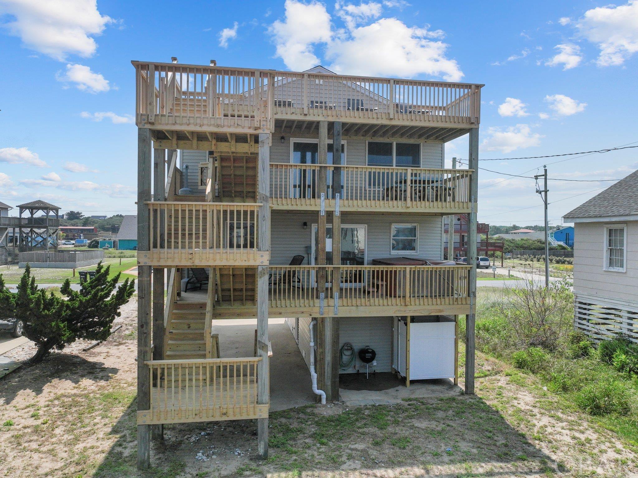 2 LOTS OFF THE OCEAN WITH OCEAN VIEWS IN KITTY HAWK! YOU WILL BE WOWED BY HOW CLOSE THIS ONE IS TO THE STARFISH BEACH ACCESS!  This home is Close to Shopping, & Restaurants. This 4 Bedroom 3 Bath OBX Beach Cottage is perfect for Vacation Rentals, Second or Primary Home. Watch the Sunrise over the ocean while sitting in your living room, on the large deck or venture up to the expansive Ships Watch deck with your morning coffee.  Enter this home from the ground floor dry entry into the game room.  The Mid-Level features all LVP flooring, a nice size media/sitting room with sliding doors out to the covered deck with access to all decks and a Hot Tub . This level also has 3 bedrooms & 2 full baths.  Top level has an open Great room/dining/kitchen combination, LVP flooring. throughout, Granite Countertops.  Custom cabinets & All Stainless appliances, covered decks for those hot days and plenty of sundecks with access to all levels. Ground Floor Storage & Outdoor Shower.   Great neighborhood for walking & bike riding! Kitchen and appliances are about 3 years old, Flooring is 3 years old. Fortified roof is 4 years old. HVAC systems are 6 years old-serviced by One Hour heating and air 2 times per year.  Next schedule date is 8/8. All light fixtures are new.