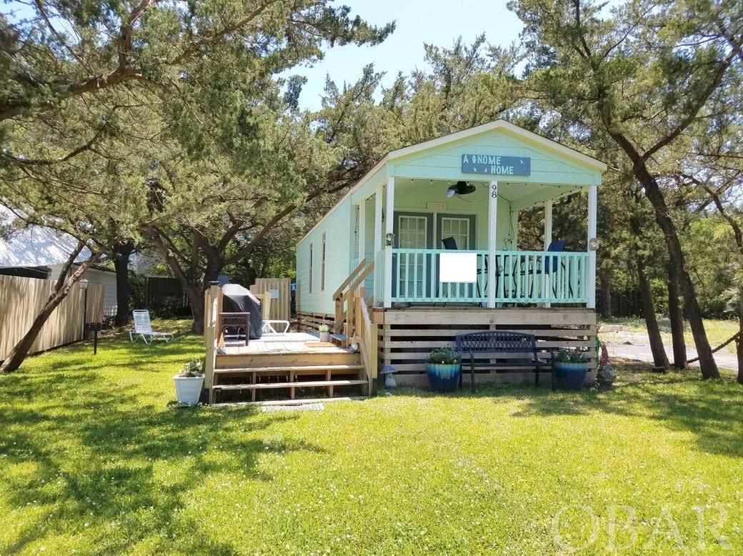 Located on a quiet, residential street just outside the heart of the village, this cute, cheerful, completely furnished, manufactured Tiny House has a generous sized bedroom and a full bath with tub/shower. You'll be surprised with the countertop & cabinet space! The interior is an open floor plan with cathedral ceilings and stackable washer/dryer. The front covered porch is perfect for relaxing. The property has a grassed yard with 10x12 storage shed, park style charcoal grill and an outdoor shower.