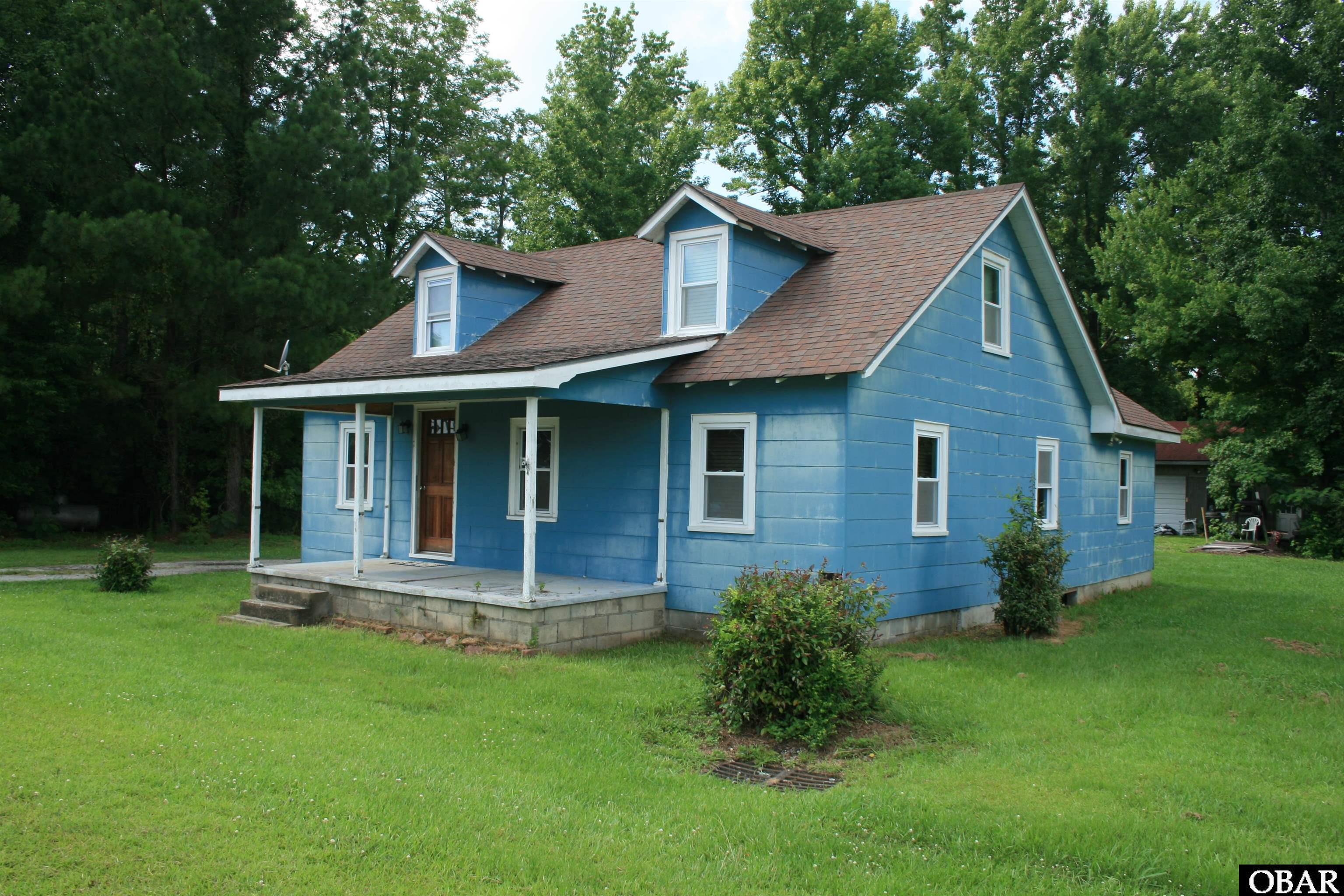 3 Bedrooms 1.5 Bath Home on approximately 2.5+/- acres of mostly wooded property.  Master Bedroom with Half Bath is upstairs.  Large Detached Garage/Workshop with Bathroom and Attached Garage/Shed behind the Workshop.  Approximately 450+ feet of Road Frontage.  Located across the road from the Seafood Market and near Columbia Shops/Restaurants and the Scuppernong River Boardwalk.  Short drive to Manteo/OBX, Plymouth, Edenton and other Eastern NC areas.