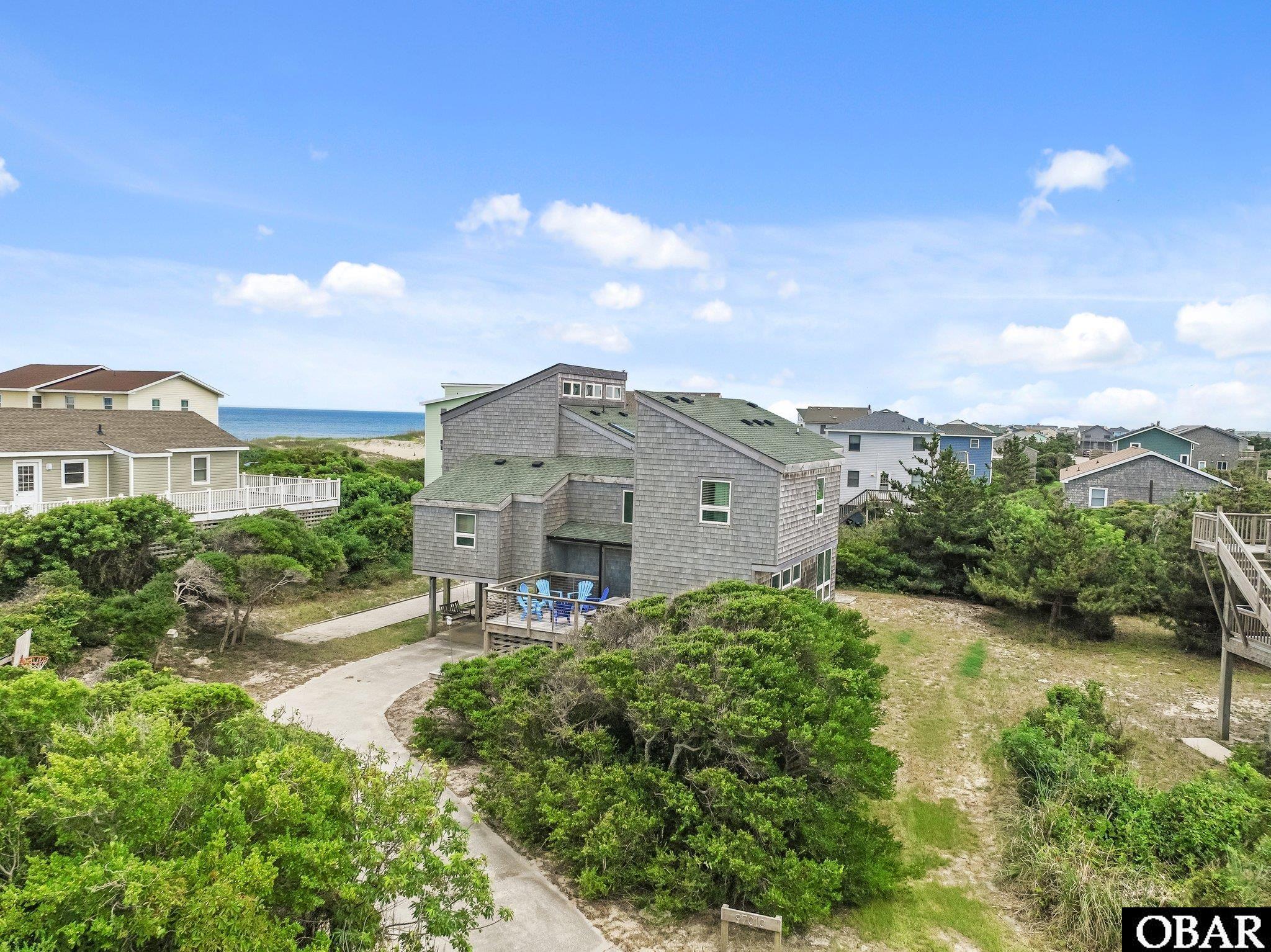 Just steps to the beach, this split level contemporary house has been in the family since 1974 but underwent an amazing renovation by award winning contractor, Jason James with ACS and designed by award winning architect/owner, Rence Callahan. The lower floor is currently being used as an additional living area with wet bar but will make a great game room. There is a flex space with fabulous light that will make a fantastic office or yoga room on this floor too. Going up to the next level you will find the 3 original bedrooms. One of these was the original primary suite. There is an additional bathroom with shower for the other two bedrooms on this floor. Up from there, you will find the new and spacious primary suite with ocean views. This space is divided by the closet offering sleeping quarters on one side and office space on the other. The ensuite bath completes the space. As you climb the stairs to the top floor, you will be greeted with sweeping ocean views, a living room, dining area and a refreshed kitchen with stainless appliances and quartz countertops. You will enjoy multiple outdoor decks and spaces.  The exterior has a great yard with a Bocce Ball court and horse shoes surrounded by greenery to offer privacy. Don't miss this amazing opportunity! The design provides for maximum airflow throughout the house.