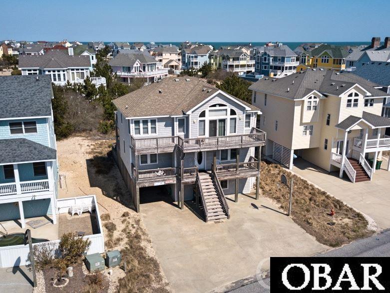 This spacious updated beauty is just a straight short walk to the ocean, and would be great as a rental or your next home. You'll have your choice between your own private backyard pool and hot tub or the association pool only 3 houses away. Downtown Corolla, with its many restaurants and shops, are also just around the bend. On the ground level you'll find two bedrooms and a game room leading out to the pool deck. The second flood has three more bedrooms, a den, and a large deck with hot tub. The top floor boasts the primary bedroom and ensuite as well as the living room, kitchen, and massive screened porch. This house has both the space and the location to delight your family or renters!