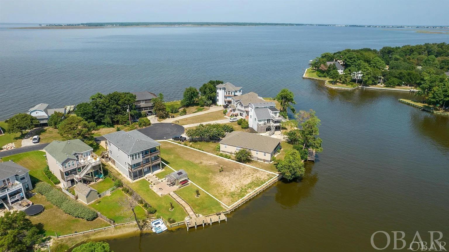 Beautiful Waterfront Lot with a Lake sized Canal, that opens up to Eagleton Point, and then into the Albemarle Sound! With over 80ft. of New Bulkhead installed in 2021, this property's proximity to the sound offers various water based activities, such as sailing, fishing, boating, kayaking and paddleboarding, making it an ideal location for outdoor enthusiasts and water lovers! Clipper Court is a private Cul-de-sac within a short walk or bike ride to Colington Harbour Soundside park. Which includes a sound front beach, picnic area, boardwalk, boat ramp and playground. You have the option to join the Colington Harbour Yacht & Raquet Club to enjoy the Olympic sized Sound Front pool, Tennis Courts and Clubhouse. Explore the possibilities of building your dream home, with it's cleared and open space, protective bulkhead, and spectacular Sunsets, this property invites you to create a remarkable living space that seamlessly blends with the natural beauty of the surrounding water.
