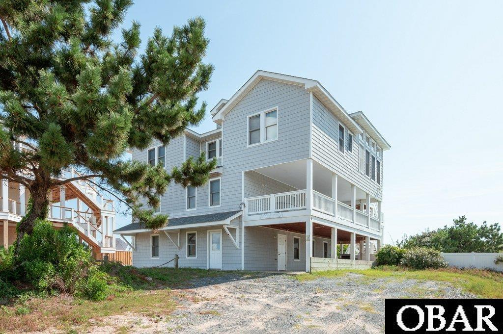 EXQUISITE "LUXURY" BEACH LIVING. This "WELL MAINTAINED" stunning home is topped off with the most magnificent Sunrise views of the Atlantic Ocean and Sunset views over the Currituck Sound. Located on the ever sought after 4X4 Beaches of Corolla, also home to the Majestic "Wild Ponies" and numerous other species of wildlife.     Enjoy gorgeous panoramic ocean views and watch the dolphins play or sit on the large, covered side deck while enjoying your coffee, a hammock and near daily visits from the wild horses. The beach is a short walk over the dunes on your private walkway that was completely rebuilt in 2021. The top floor of this open reverse floor plan has a large, open great room along with a powder room and 2 master suites and a deck running the full east side of the house to enjoy the sunrise. The second floor holds four master suites with renovated bathrooms and a large, covered side deck as well as a beach facing deck running the length of the house. The ground level has two bunk bedrooms with a large jack and jill bath, powder room, laundry room and second entertaining area with a kitchenette. This second living space is great for the kids to play video games or hang out while the adults have their own gathering space on the top floor.  In addition to enjoying the beach just steps away, this home boasts a private pool and newer (2020) hot tub. There is even a shallow kiddie pool built into the pool deck! The pool area is to the south of the house. Adjacent to the pool there is a lavatory, a shower and a beach toy storage room.   With many improvements since 2020, including new siding, new roof, a new well, fresh interior paint, and 2 of 3 HVAC units replaced, this well-maintained home is ready for you to enjoy along with your friends and family or put it in a rental program for great ROI. This home is not currently in a program but was as recently as 2022 and showed strong returns. LOCATED IN AN "X"FLOOD ZONE...WHICH MEANS...NO FLOOD INSURANCE REQUIRED!!!