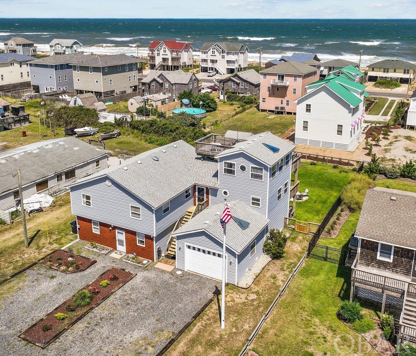 Kitty Hawk property just two lots away from the Oceanfront. Currently zoned BC-2, the opportunities are plentiful! A new ELEVATOR was installed in 2020. This is a legal duplex with two separate meters. Current owner lives on the top level and rents the downstairs as a year round rental. The top level features 3 bedrooms, two are ensuites, one with an ocean view. There is also a bonus room/game room on this level for whatever best fits your needs.  A 19x15 ship's watch room is currently used as an office. The office has access to both a deck and an exterior crows nest with water views.  Sunrise and sunsets have been enjoyed from this special location. There is a spacious open concept kitchen, dining and living room. Newly added rear deck for enjoying ocean breeze and OBX sunshine. Lower level apartment features 2 bedrooms, 1 bathroom, kitchen, living room and dining area. Lower level apartment was recently renovated including all new bathroom, flooring, paint, trim. There is a large 40x17 garage. An additional side workshop area with built-ins is a handy person's dream come true..  Extensive list of updates and upgrades available for review.  The rear yard is fenced and beautifully landscaped.. The property is just ½ block from two beach accesses, one of which currently has a lifeguard stand during the Summer at Byrd Street. The other is Fonck St. Recent updates include: Flooring, elevator, paint, landscape, irrigation, doors, decks, stairs, security, apartment bathroom and kitchen updates and more. New Roof 2013 per previous owner. A full list of updates are available for review. Ensuite bedroom and the office have split system HVAC. Current downstairs tenant pays $1525 month lease ends Nov. 30 2023.