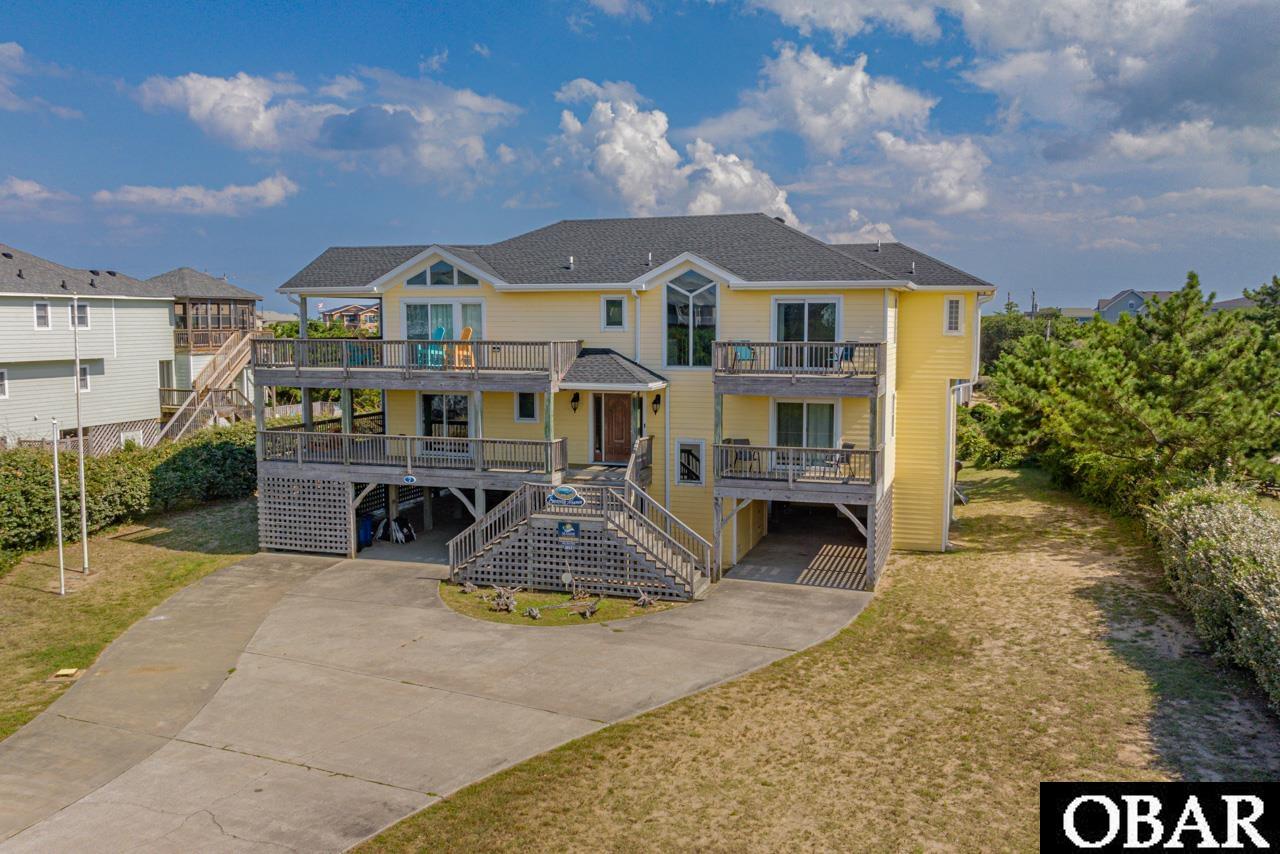 Escape to your dream coastal oasis on Seventh Avenue, just steps from the ocean in Southern Shores. This lovingly maintained 6-bedroom, 5-bathroom home offers the ultimate seaside sanctuary. With its private heated pool, relaxing hot tub, and even a volleyball court -- it's a paradise of your own by the beach. Inside, an open and spacious floor plan welcomes you, ideal for both family gatherings and entertaining friends. From hosting a beach vacation to creating cherished memories, this home effortlessly accommodates all your needs. The first level houses four private bedrooms, including two en-suites, ensuring comfort and privacy for everyone. An additional den and access to the covered deck with a hot tub overlooking the pool provide ample space to unwind. There is also an oceanside hammock for later afternoon naps after a long day in the sun. The top level is a true delight, showcasing expansive ocean views. Here, you'll find two more bedrooms, including a private en-suite, and a well-appointed kitchen with granite countertops and stainless steel appliances. Prepare an evening cocktail at the open wet bar and step onto the wrap-around deck, complete with a screened-in area for alfresco dining while enjoying the ocean breeze. For an even more awe-inspiring vista, ascend to the rooftop deck and immerse yourself in the coastal beauty. Southern Shores offers more than just stunning beaches. Take advantage of community beach accesses, playgrounds, and a serene soundside park. For a small additional fee, join the Southern Shores Civic Association and Boat Club with a marina and boat ramp, or the Tennis Club for additional activities. In today's market, homes like this are a rare gem. Seize the opportunity to embrace coastal living at its finest. Schedule your private tour today and transform this Southern Shores home into your own piece of paradise!!
