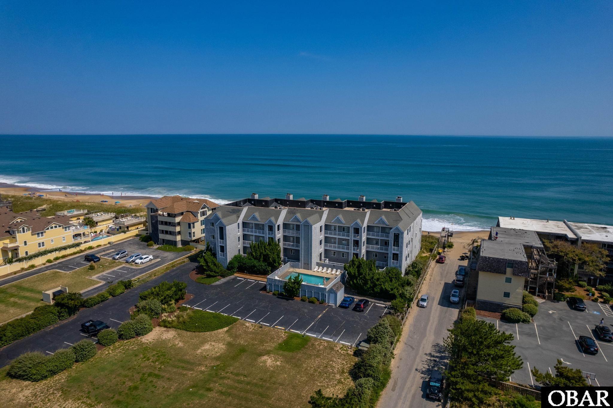 Oceanfront, Oceanfront, Oceanfront...this is the perfect Outer Banks home, as a large (1,973 sf) 3 bedroom Luxury Oceanfront condo, with excellent ocean views, with the easiest & most direct beach access you will find, beautifully remodeled & with stylish furnishings and décor, providing high rental income if desired ($89k projected annual owners rents with full availability), all in the prestigious Crystal Shores Condo complex, offering a community pool, elevator, covered reserved garage parking, & centrally located! Enjoy the 32' wide private & covered oceanfront decking, with composite deck furniture, then literally walk 15' from your private deck steps directly to the steps to the beach.... and back and forth all day. Inside, you will find an opulent 1,973 sf design, offering a bright and open great room, featuring 9' ceilings, wood burning fireplace with custom mantle, and great ocean views through the 20 linear feet of 8' high oceanfront impact sliders and windows! Ocean views from the connected dining & kitchen areas as well, and from the large main en-suite bedroom, also with 8' high oceanfront impact slider and glass, and walk-in closet. 2 comfortable sized bedrooms, foyer, dedicated interior laundry room, and lots of storage round out this floor.  Very comfortable and stylish floorplan, diagram in photos. This 2021 remodeled home features all new flooring, granite counter tops, modern wood kitchen cabinets, stainless steel appliances 2021, furnishings, décor, modern bath vanities 2021, high quality window treatments 2021, 2021 bedroom windows, 2015 oceanfront glass and sliders, 2021 HVAC system & water heater, 2022 washer and dryer, among many other upgrades, all to the benefit of the new owners. This stylish home offers high quality and attractive furnishings, décor, artwork, and  window treatments, including floor to ceiling drapes along the oceanfront, blackout drapes in bedroom, 4 mounted TV's, fully stocked kitchen with stone topped island and 4 top bar with stools, together with modern appliances and mechanicals, high end deck furniture front and rear, this home is ready for immediate enjoyment. This property is offered furnished, with some exclusions of primarily living room furniture, exclusions list provided.  #103 is located in the middle of the first level, and the direct beach access cannot be overstated, will be appreciated daily, an easy skip to the beach and community grilling area, and to the garage and car with just one flight of stairs. This is a rare opportunity within the exclusive and closely held Crystal Shores community, with just 15 homeowners, many long term and 2nd home owners, offering a sturdy concrete structure, parking garage with reserved space, large garage area owners storage room, elevator, community pool, dune top community decking, all centrally located.  Take advantage of this unique opportunity and enjoy for personal use, and/or personal use along lucrative annual vacation rental income. This is a very popular vacation rental, excellent guest feedback, generating $70,000 advertised income in 2023 with owners personal use, in just 13 rental weeks! $89,770 projected rental owner income for 2024 with full availability (rental reports and projections available).  Well established and well run community.  Schedule your virtual or in person showing today.  The property is currently booked from 9/16 to 9/30, then 10/7 to 10/14, blocked off other dates and beyond.  The owners have very much enjoyed this home, but are prepared to pass along to a new family to do the same. Additional photos, cut and paste: https://www.mylisting.cloud/sites/drkabrl/unbranded#&gid=1&pid=1