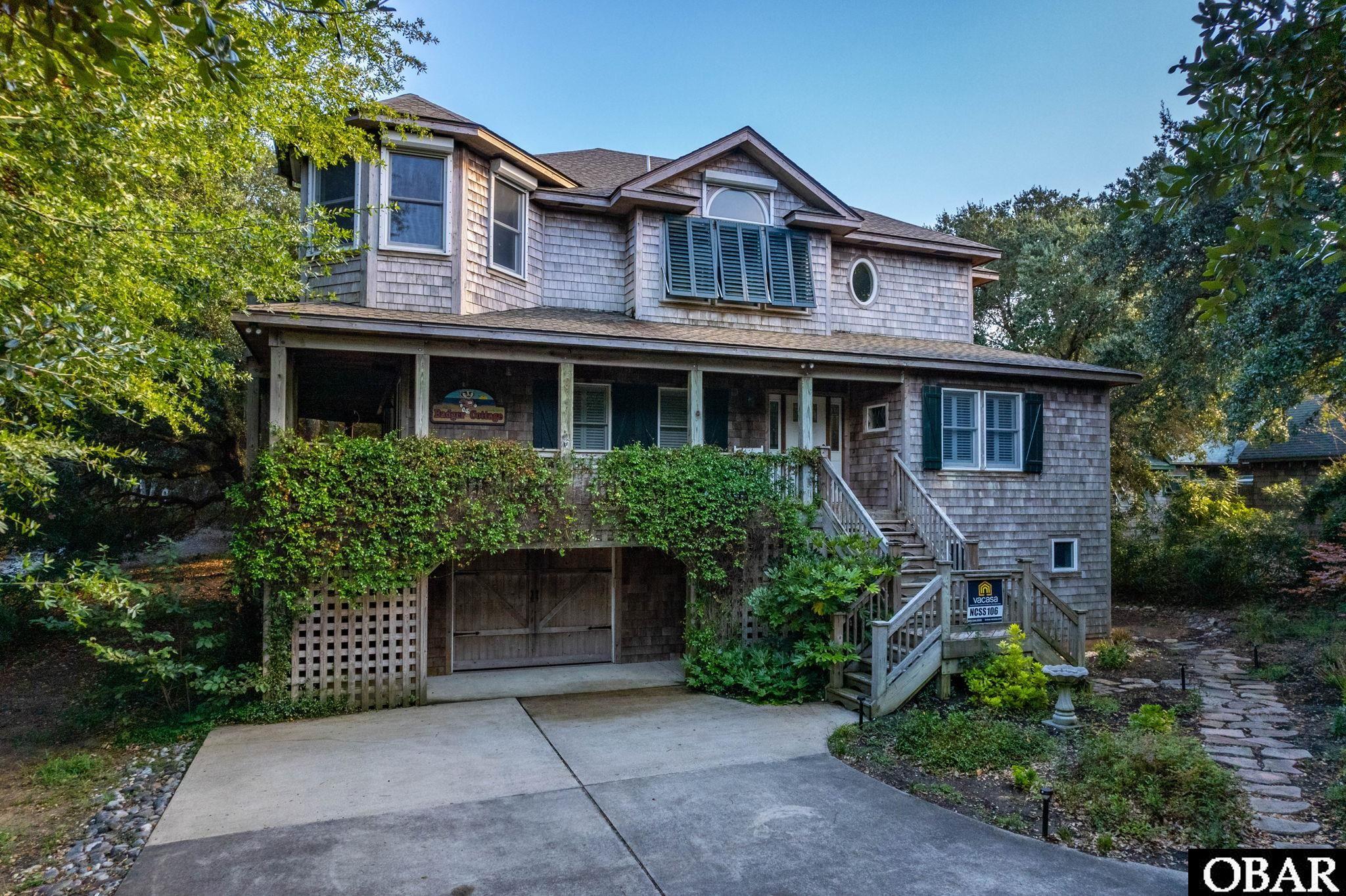 Resting amid beautiful oaks and natural landscaping you will be lured into a beautifully designed curated home either as a primary residence, second home, or as an excellent investment opportunity.  Formerly known as Bee's Knees, this home generated over $120,000 in 2021.   More recently known as Badger Cottage, the owners have enjoyed family time here as well. There is room for parking in the garage which opens directly into the primary residence for a dry entry.  On the ground level you have ample closet storage as well as a room for beach supplies or baby items.  Also on this level is an ensuite which includes a lovely separate sitting or additional sleeping area with a retro kitchenette.  From here, the french doors open up to an expansive irrigated back yard.   On the 2nd level there are 3 bedrooms, each with their own bath and two of the master suites each opening onto the deck for hot tub access.  The third bedroom is a unique kids room with bunk beds. This level also includes 2 large storage or locked owners closets and includes a sizable laundry area.  On the top level, the cathedral ceilings, fireplace, reading nook, and living area offer warmth, richness, and interest at every turn.  The large well curated kitchen leads to a lovely screened in porch and private outdoor dining area on the shade-covered deck that is sure to be a unique gathering spot.  This beautiful home balances form and function so well you need to see it for yourself.